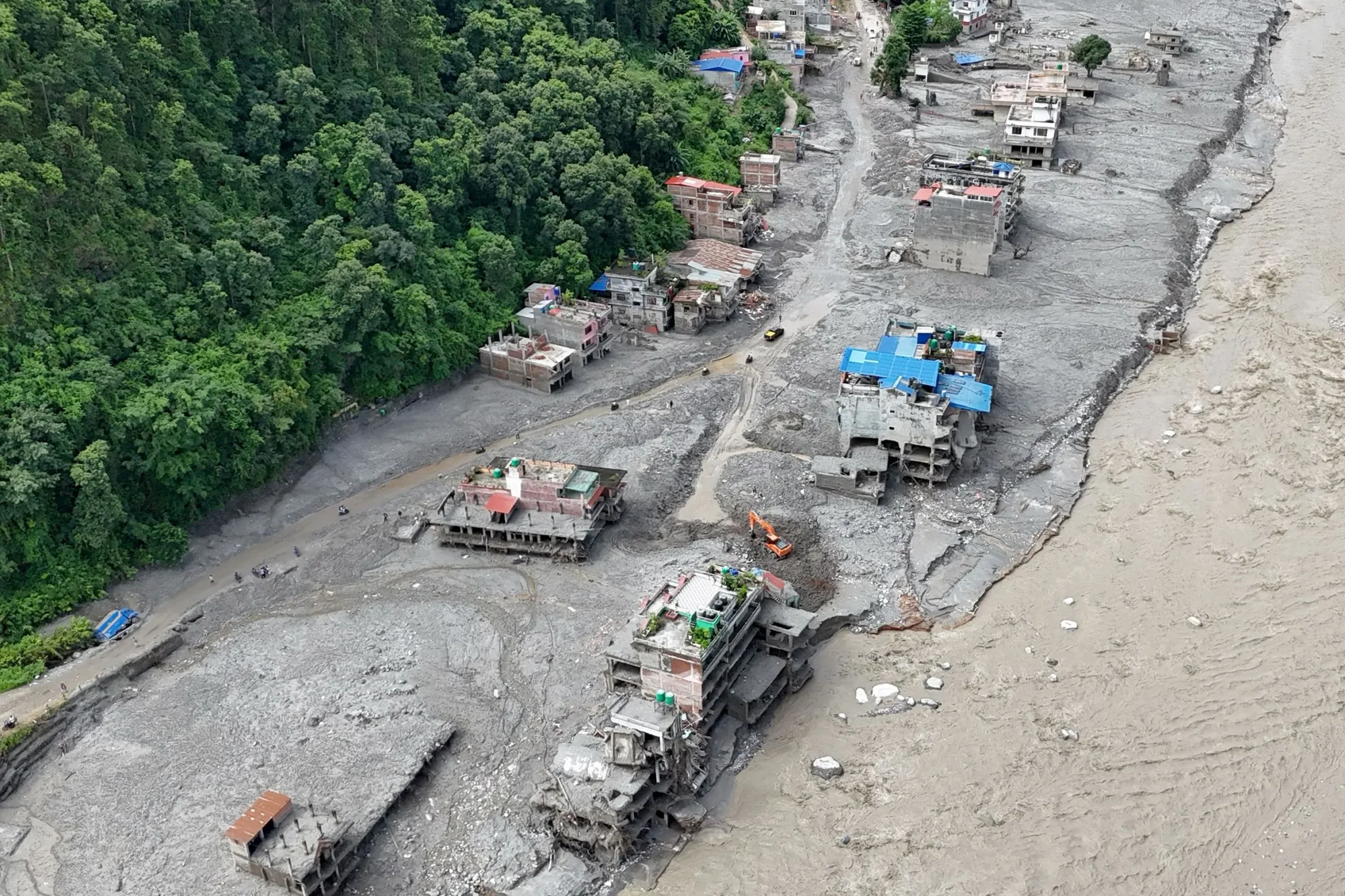 مبانٍ مدمرة ومغمورة بالوحل على ضفاف نهر في نيبال بعد فيضانات كارثية أثرت على محطة Trishuli 3A للطاقة الكهرومائية.