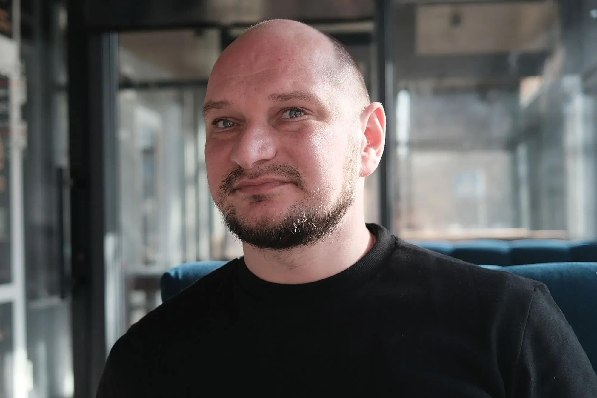 فولوديمير دودنيك، شاب أوكراني، يجلس في مكان مغلق، معبرًا عن مشاعره بعد ترحيله من الولايات المتحدة إلى أوكرانيا.