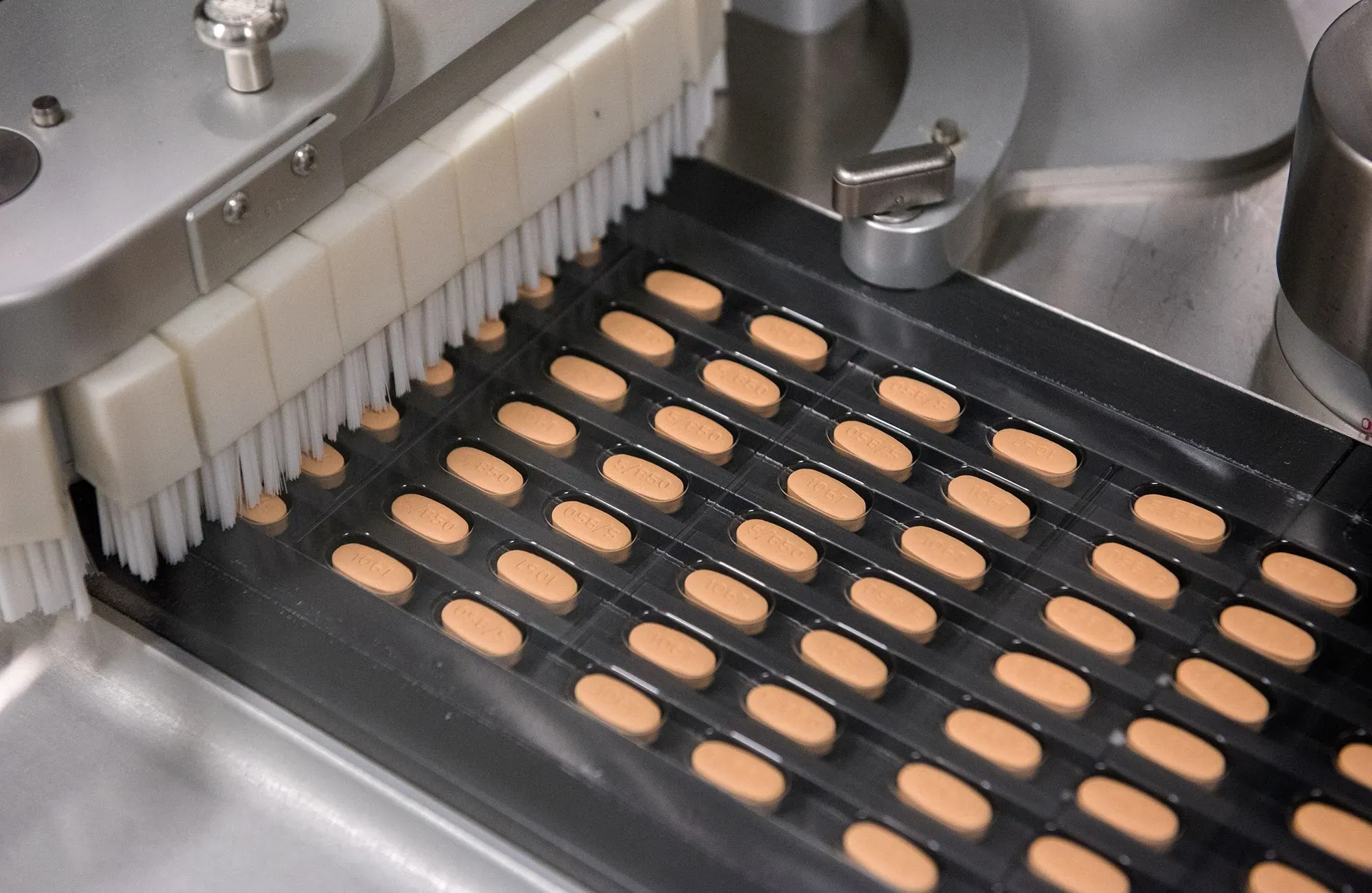 أقراص دوائية تُعبأ آليًا على خط إنتاج، تعكس جهود شركات الأدوية لتعزيز التصنيع المحلي في الولايات المتحدة.