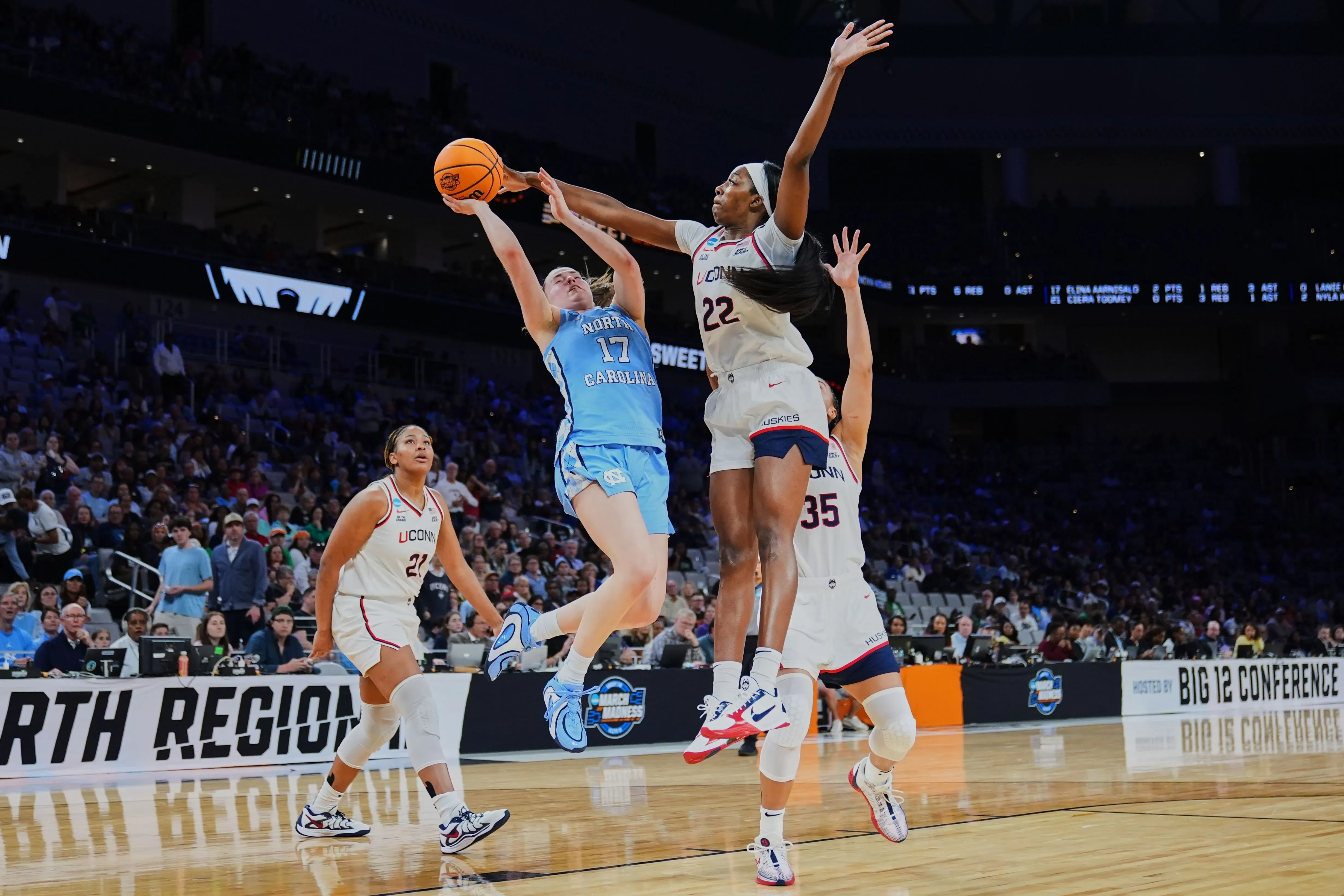 لاعبة كرة سلة من فريق نورث كارولينا تتجاوز لاعبة فريق يوكون في محاولة للتسديد خلال مباراة في بطولة NCAA.
