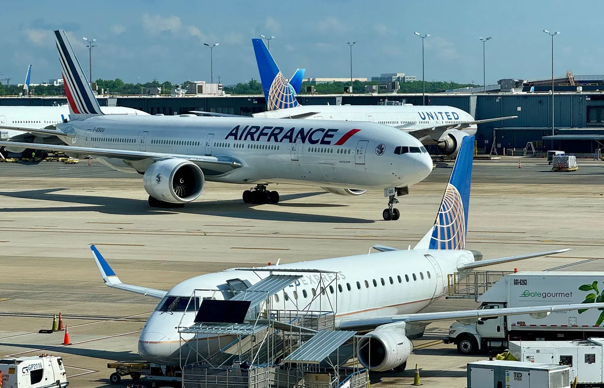 مطار دالاس الدولي يظهر فيه طائرات من شركات طيران مختلفة، بما في ذلك طائرة تابعة للخطوط الجوية الفرنسية، مع ممرات نشطة.