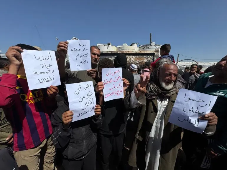 احتجاجات في المواصي بقطاع غزة، حيث يحمل المشاركون لافتات تطالب بإنهاء أزمة المياه، وسط ظروف إنسانية صعبة.