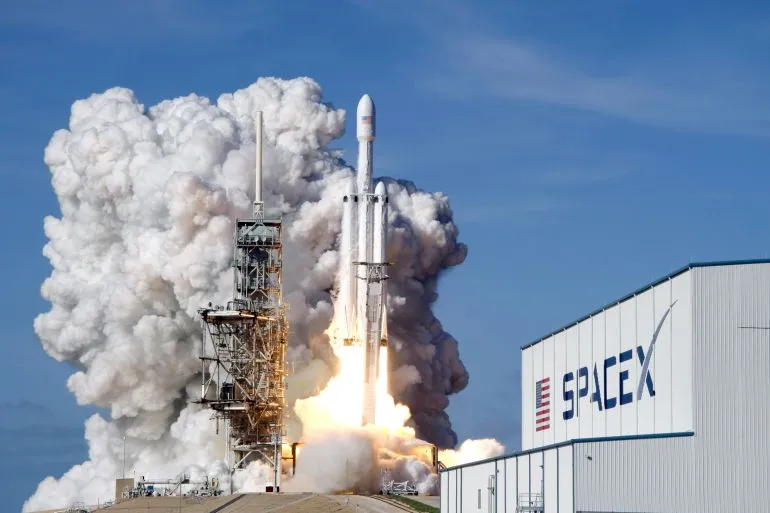 إطلاق صاروخ SpaceX من منصة الإطلاق، مع تصاعد الدخان والغازات، مما يعكس طموحات الشركة في مجال الفضاء والابتكار.