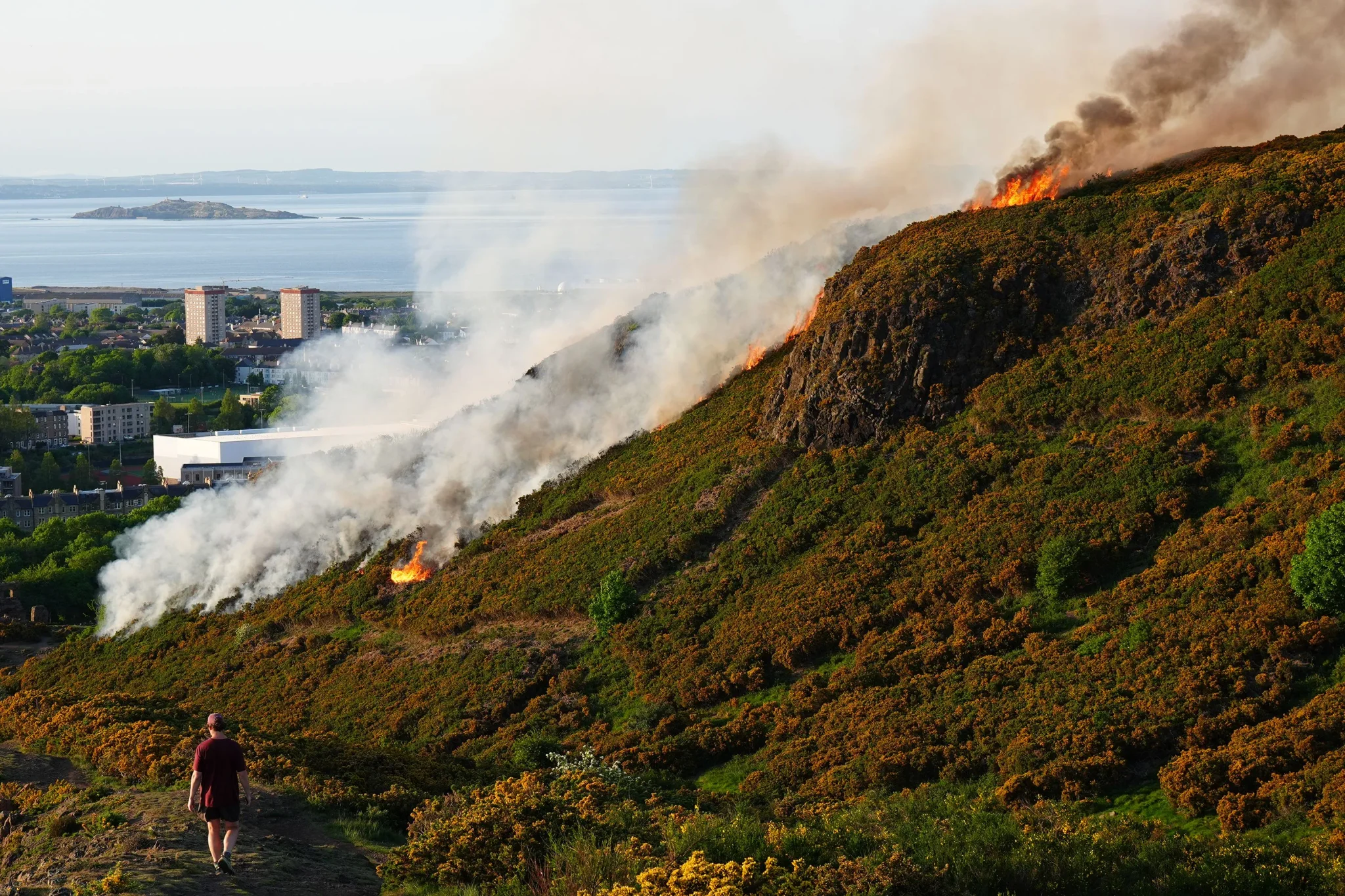 اندلاع حريق في تلّة Arthur's Seat بإدنبرة خلال موجة الحرّ في مايو 2026، مع تصاعد الدخان فوق المناظر الطبيعية.