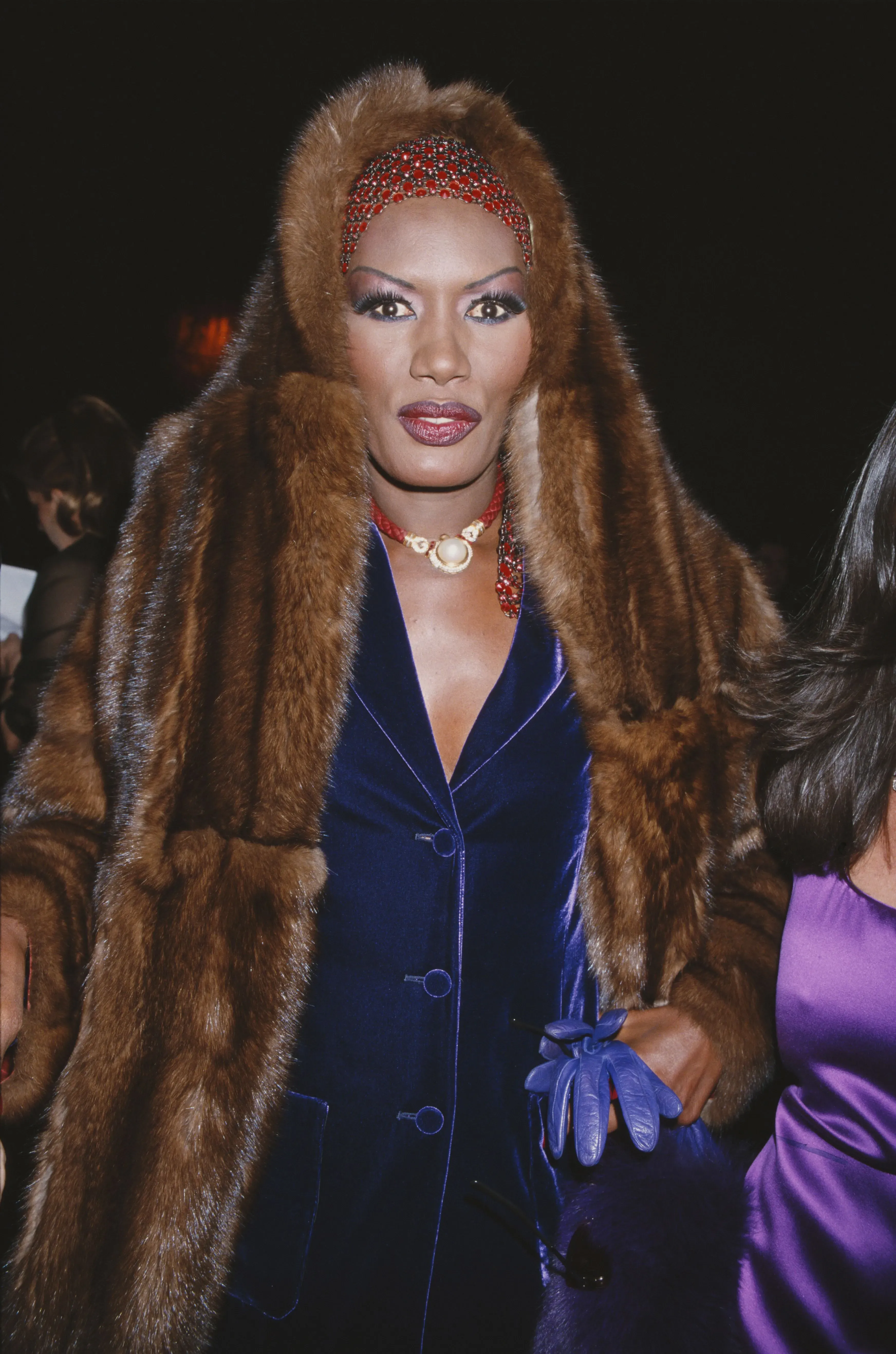 امرأة ترتدي معطفاً من الفرو البني مع تسريحة شعر مميزة، تعكس عودة الفرو إلى الموضة في سياق اهتمام المستهلكين بالاستدامة.