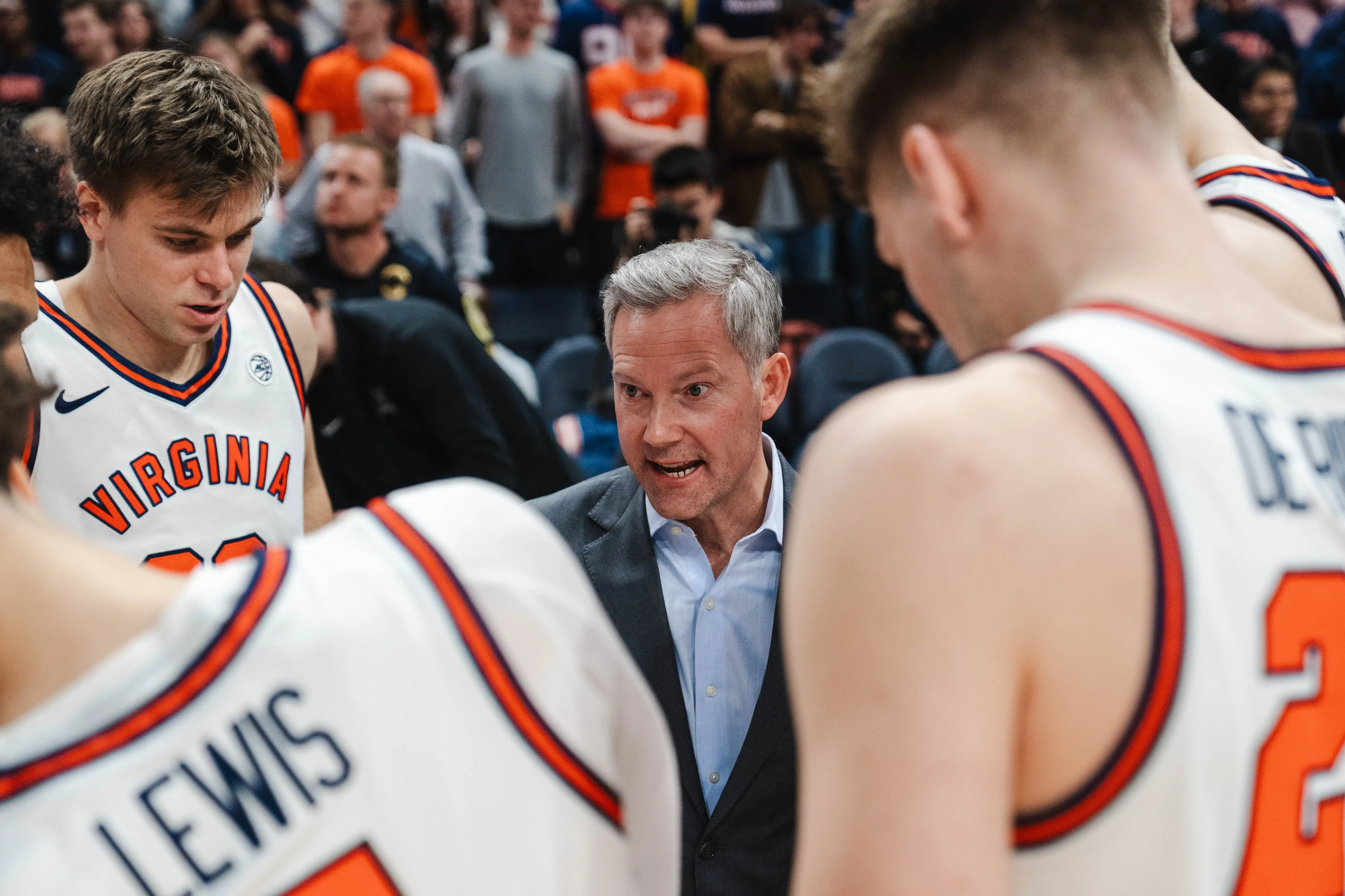 مدرب فريق فيرجينيا يتحدث مع لاعبيه خلال وقت مستقطع، حيث يركز على بناء هوية الفريق وتعزيز الروح الجماعية.