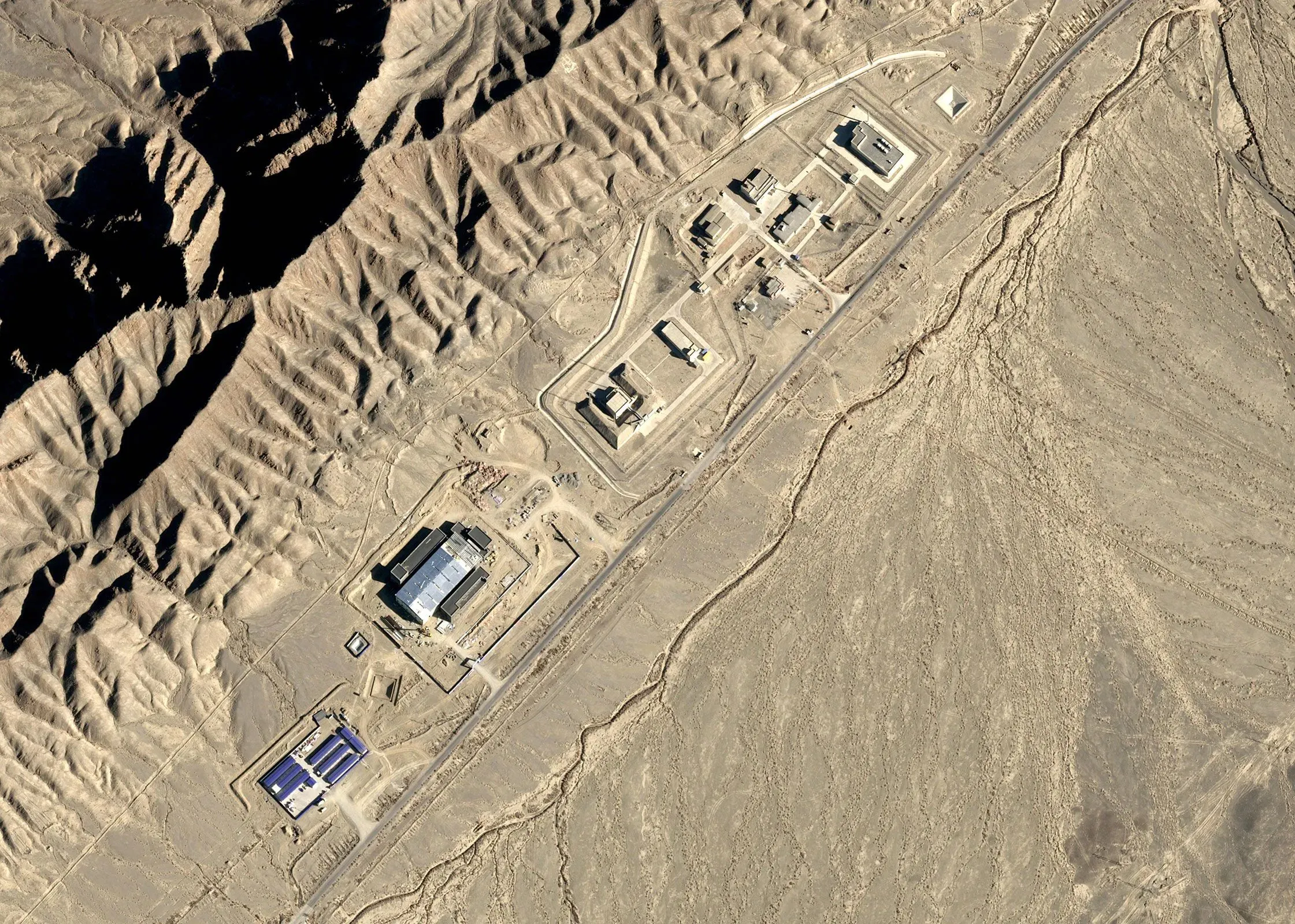 صورة جوية لموقع اختبار نووي في منطقة لوب نور بالصين، تظهر المنشآت العسكرية المحاطة بالجبال والسهول الجافة، في سياق تطوير الأسلحة النووية.