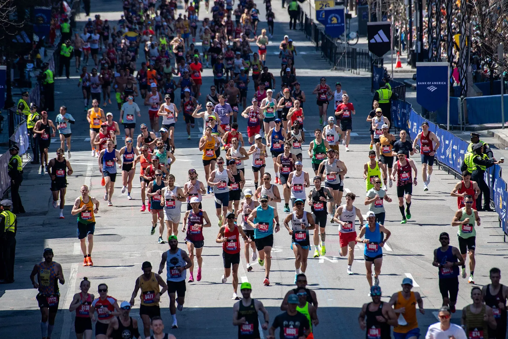 سباق ماراثون حيوي في مدينة مزدحمة، حيث يشارك عدد كبير من العدائين في مختلف الملابس الرياضية، مع وجود حشود من المشجعين على الجانبين.