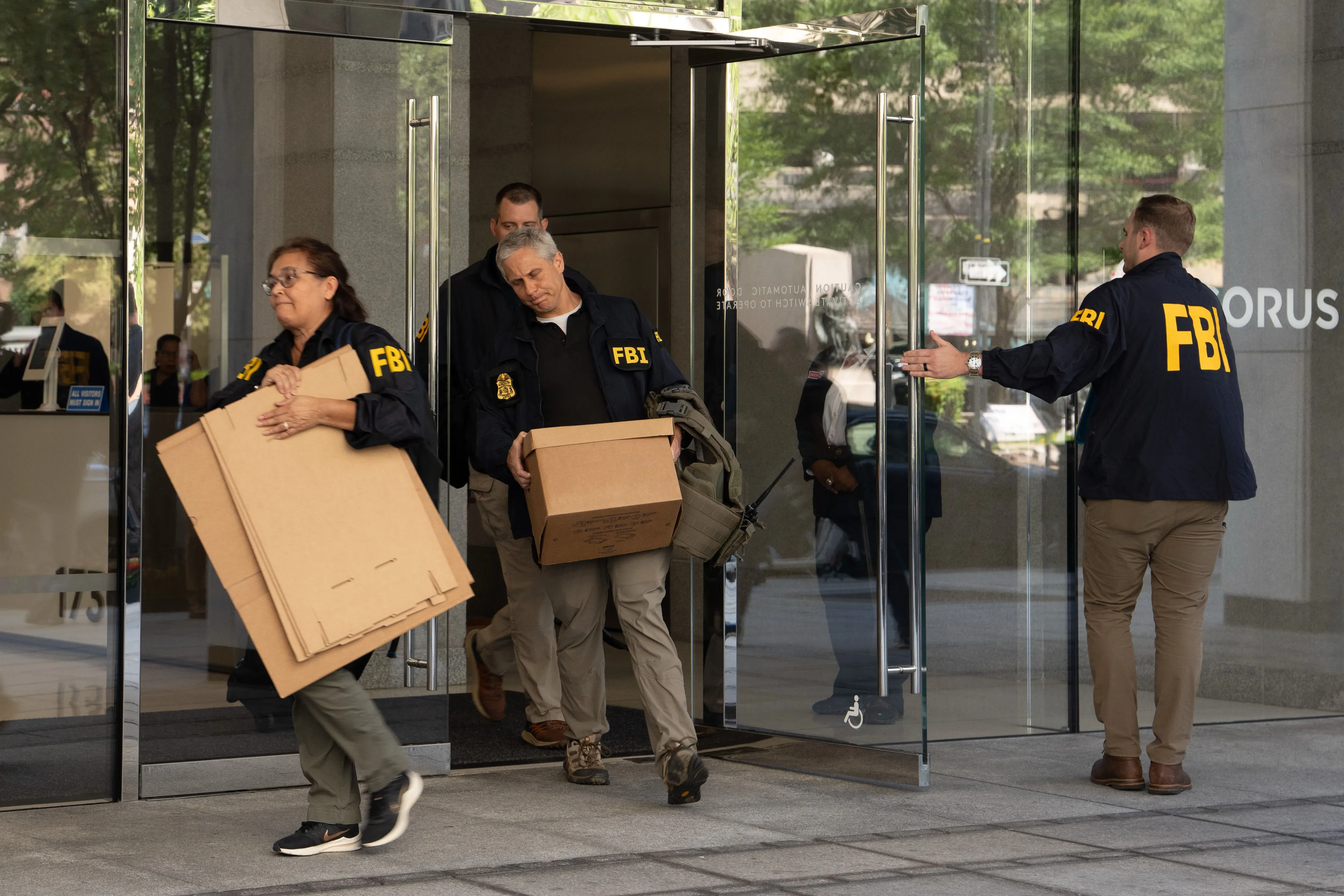 عملاء مكتب التحقيقات الفيدرالي يحملون صناديق أثناء مغادرتهم مكتب جون بولتون، وسط تحقيقات بشأن الوثائق السرية المتعلقة بالأمن القومي.
