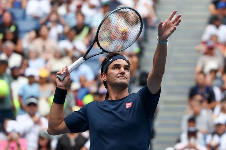 روجر فيدرر يرفع مضرب التنس في ملعب آرثر آش خلال عودته الرمزية لبطولة US Open بعد غياب طويل.