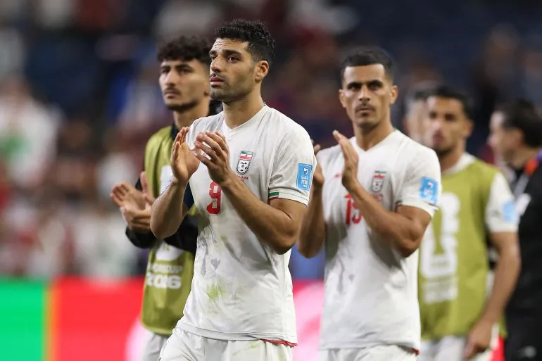 لاعبو المنتخب الإيراني يتفاعلون بعد المباراة، مع التركيز على مهدي طارمي الذي ينتقد FIFA بشأن ترتيبات السفر.