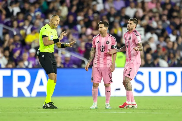 الحكم المغربي الأمريكي إسماعيل الفاث يشرح قراراً للاعبي فريق إنتر ميامي خلال مباراة في دوري MLS لكرة القدم.