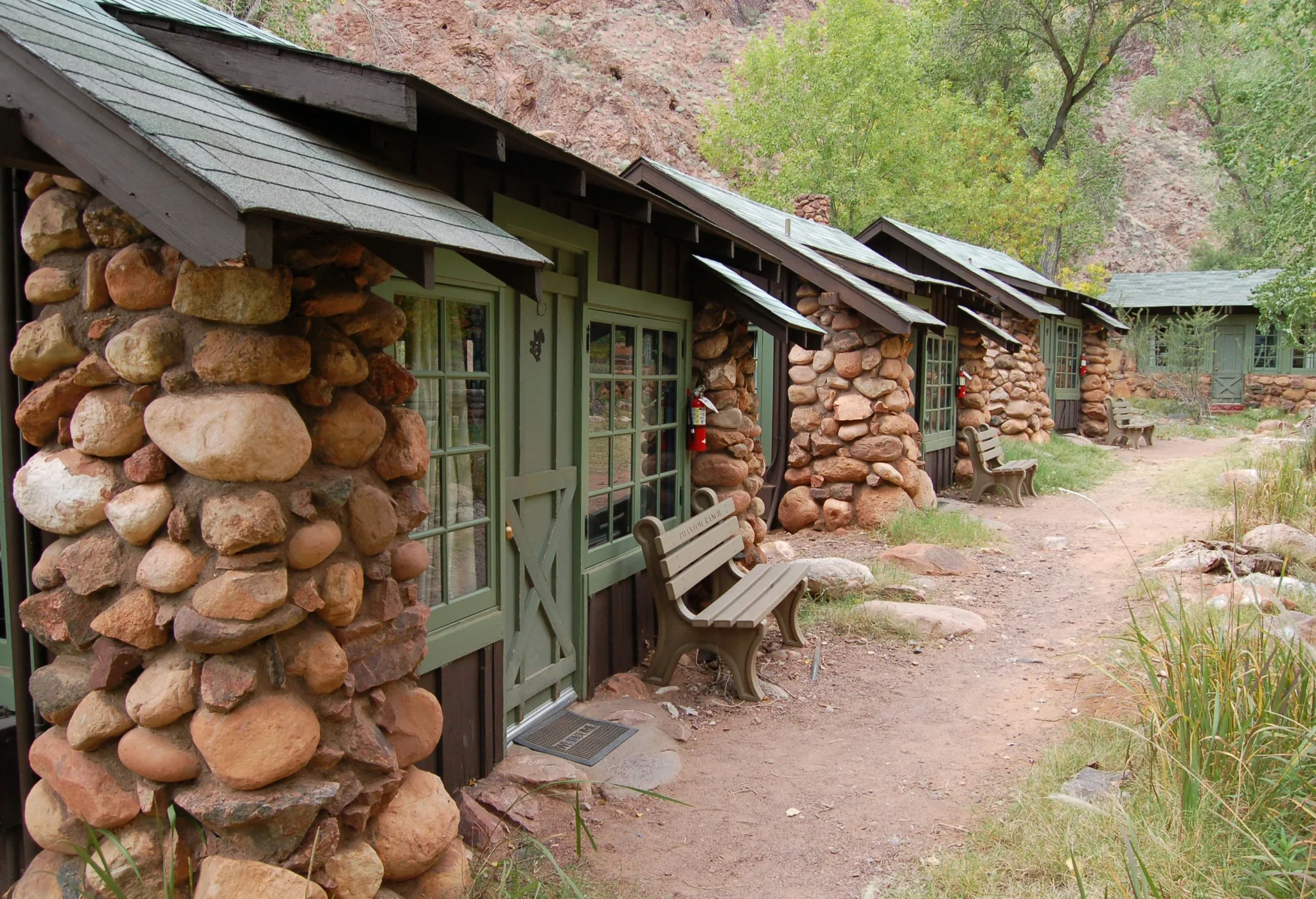 أكواخ حجرية تاريخية في محطّة Phantom Ranch داخل وادي Grand Canyon، تعكس التراث المعماري المتأثر بالتغيرات المناخية والفيضانات.