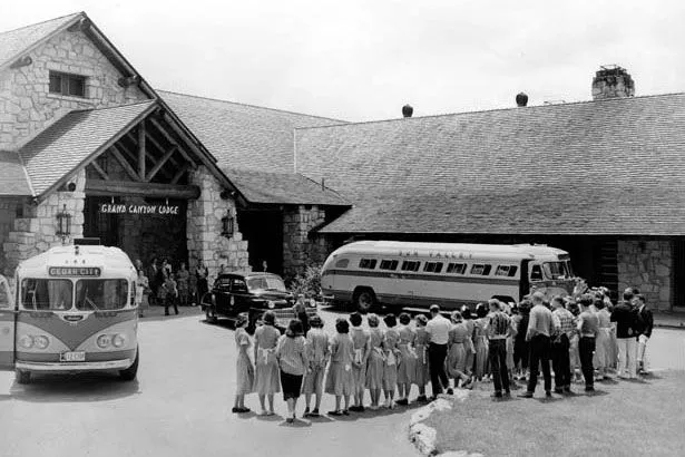 مبنى Grand Canyon Lodge التاريخي عام 1928 مع حافلات وزوار أمامه، يعكس التراث السياحي في وادي Grand Canyon قبل حرائق 2025.