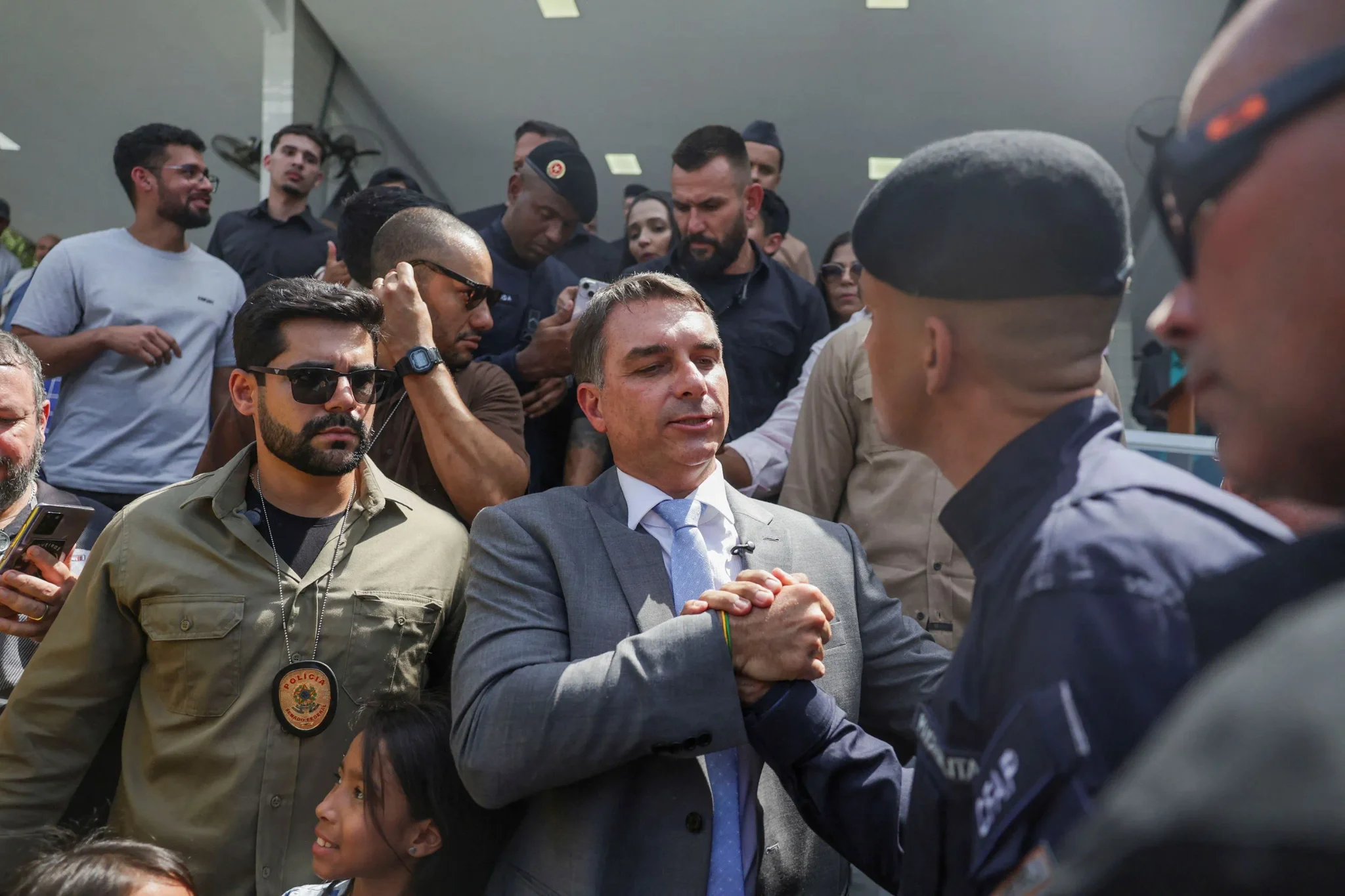 فلافيو بولسونارو في لقاء مع رجال الأمن وسط حشد من المؤيدين، في سياق حملته السياسية المثقلة بالتحقيقات القضائية في البرازيل.