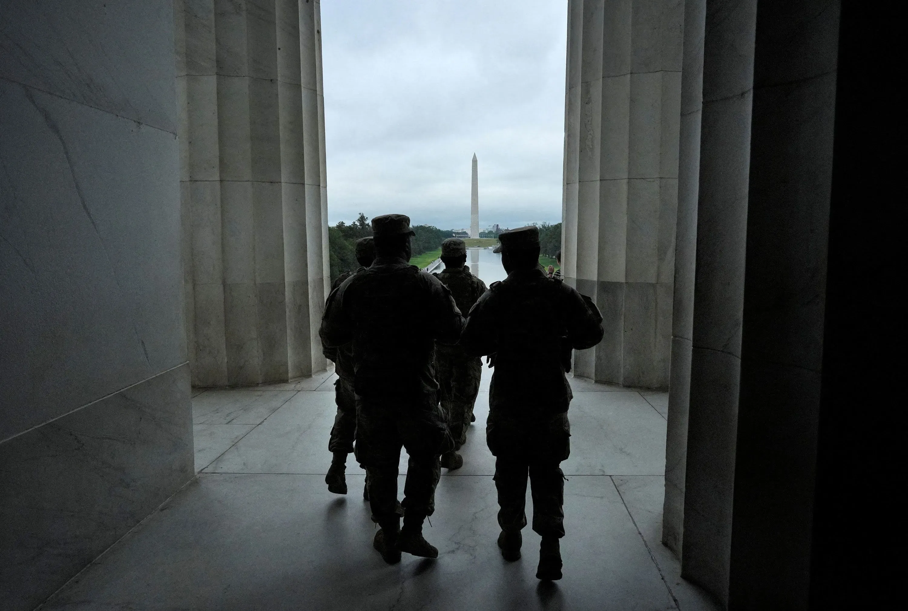 مجموعة من الجنود يسيرون نحو النصب التذكاري في واشنطن، في إطار جهود ترامب لتوسيع استخدام الجيش في إنفاذ القانون.