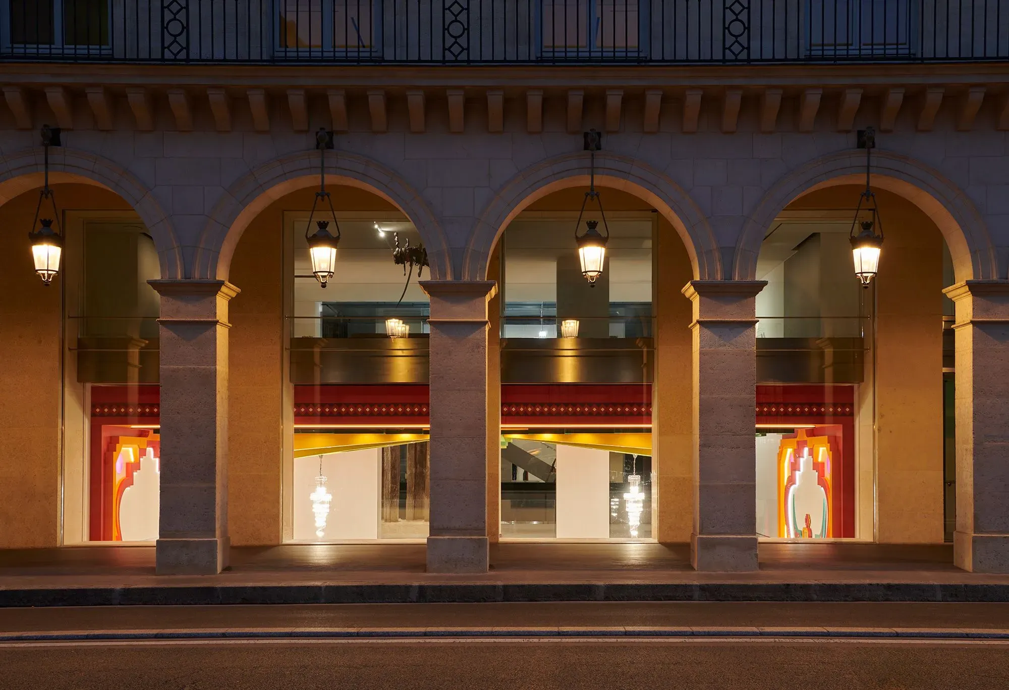 واجهة متحف مؤسسة كارتييه للفنون في باريس، تظهر أعمدة معمارية أنيقة، نوافذ كبيرة، وإضاءة ساحرة، تعكس التصميم العصري للمساحة.