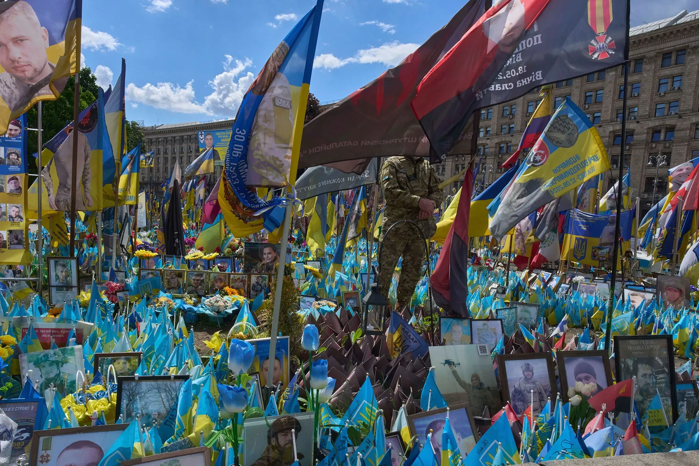 نصب تذكاري في ساحة كييف مزين بأعلام أوكرانية وصور لجنود، يعكس التأثير العميق للصراع في أوكرانيا.