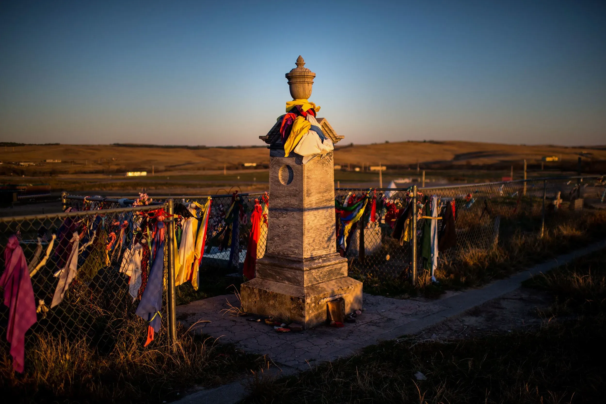 نُصب تذكاري مزين بأقمشة ملونة في موقع مذبحة الركبة الجريحة، يرمز إلى ذكرى الضحايا وأهمية التاريخ في الذاكرة الجماعية لشعب لاكوتا.