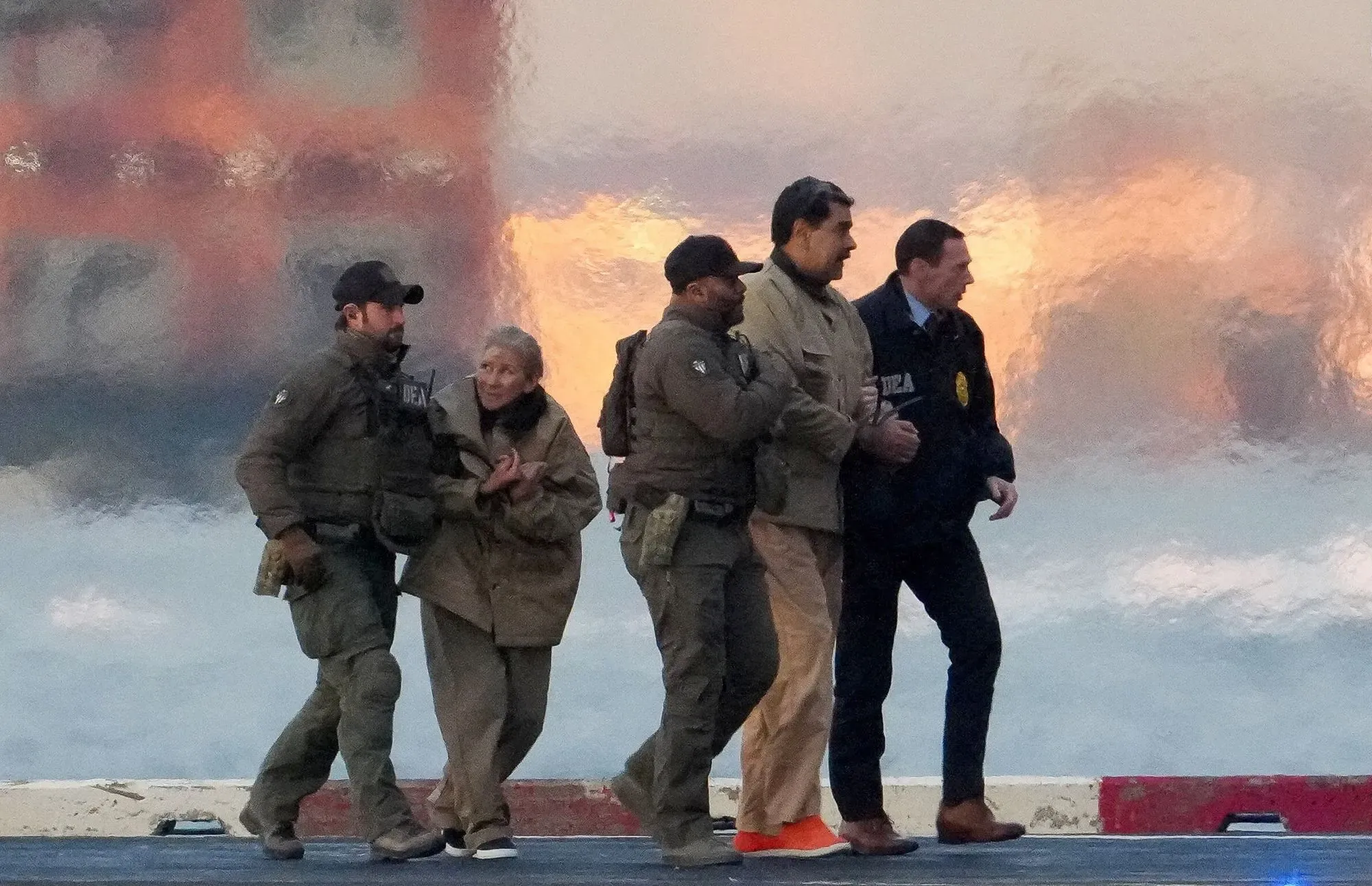 اعتقال شخصين من عصابة ترين دي أراغوا في عملية مشتركة بين السلطات الأمريكية والكولومبية، مع خلفية مائية مشوشة.