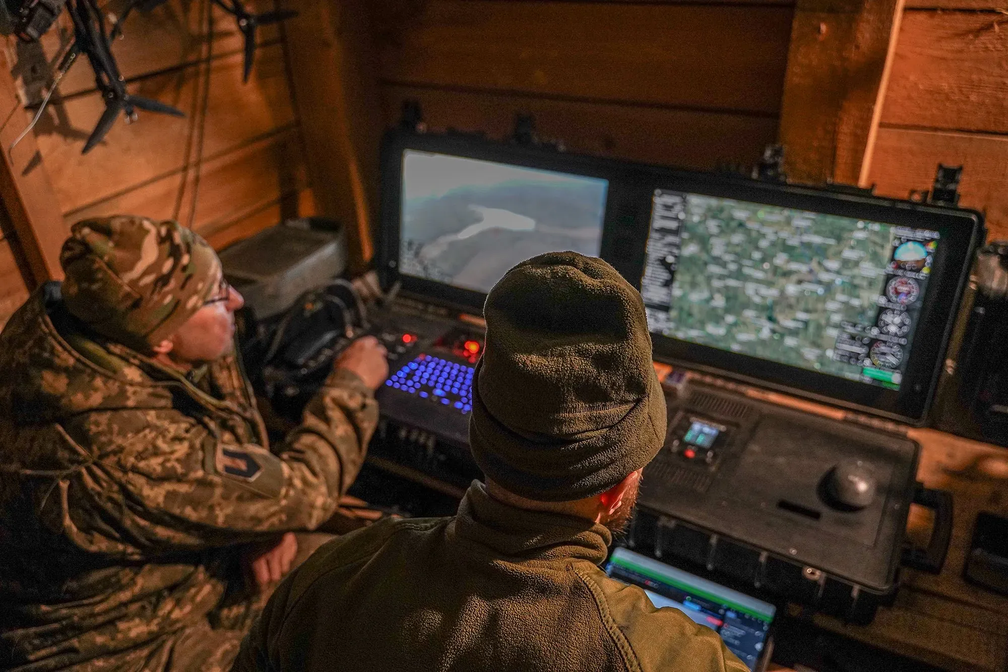 جنود أوكرانيون يتابعون العمليات العسكرية عبر شاشات كمبيوتر في موقع متقدم، مع التركيز على استخدام التكنولوجيا الحديثة في الحرب.