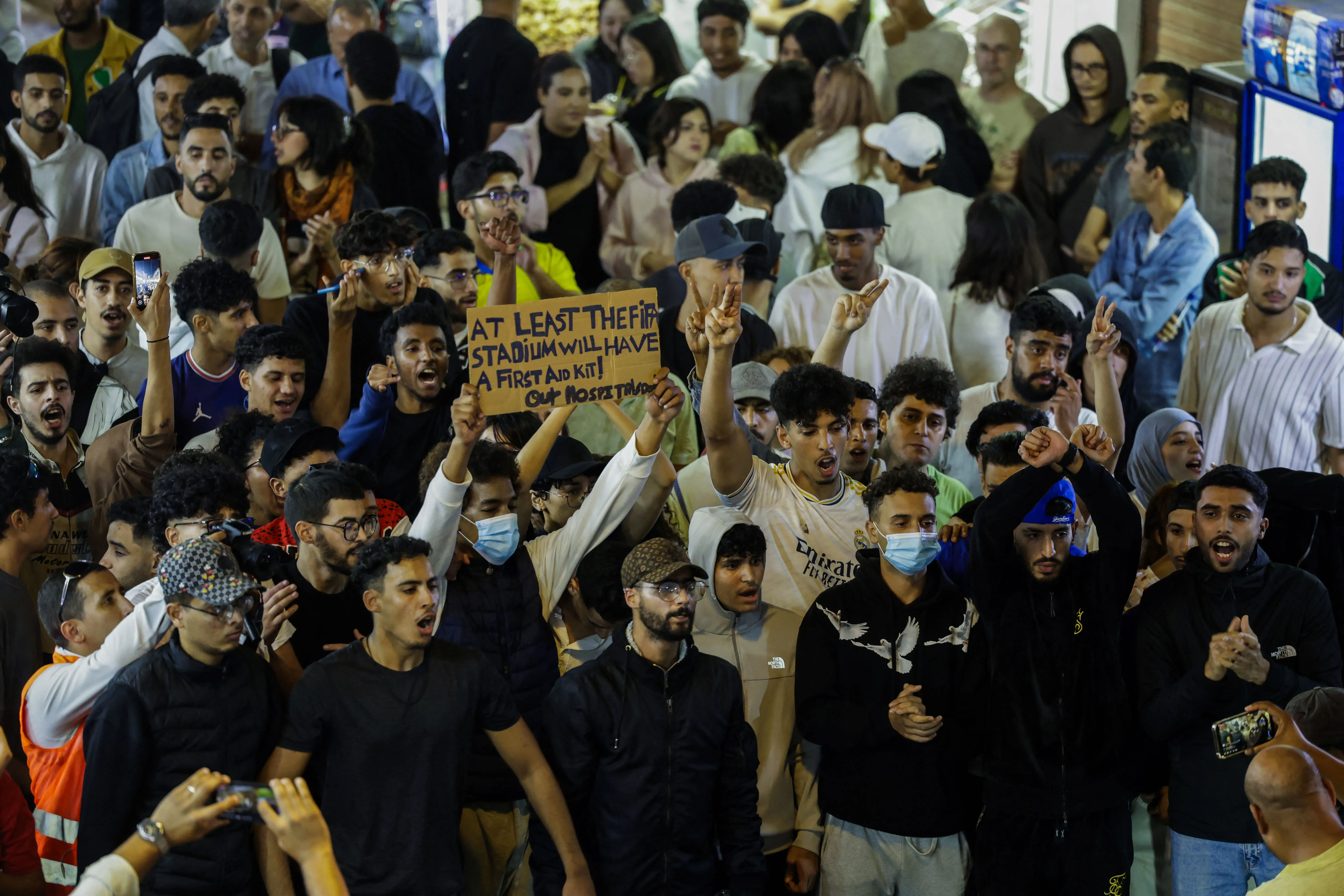 محتجون من جيل الشباب في المغرب يتظاهرون مطالبين بإصلاحات في الرعاية الصحية والتعليم، مع لافتة تشير إلى نقص الخدمات.