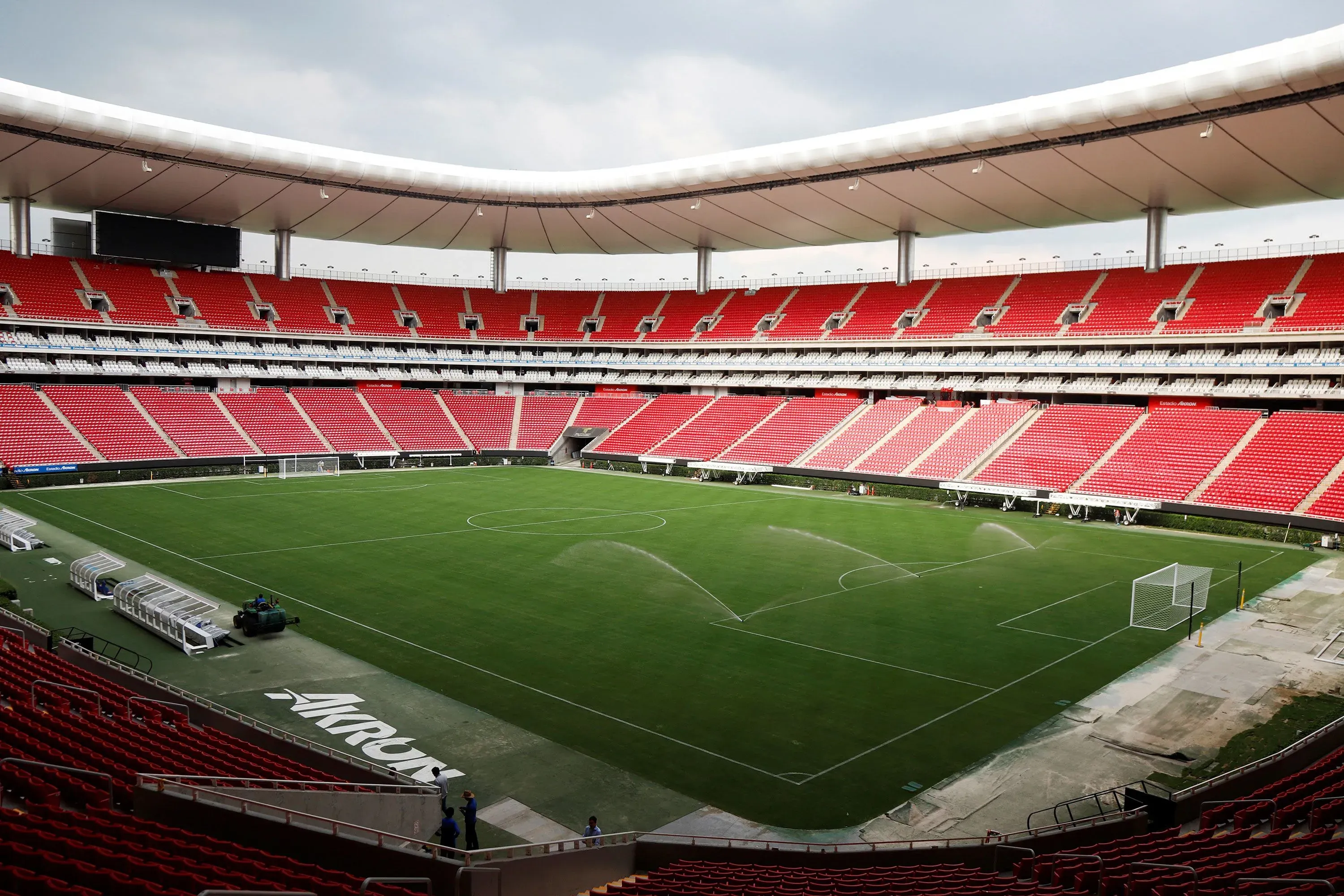 استاد كرة القدم "أزتيكا" في مكسيكو سيتي، يظهر مدرجات حمراء فارغة وأرضية ملعب خضراء، يشير إلى الاستعدادات لاستضافة كأس العالم.