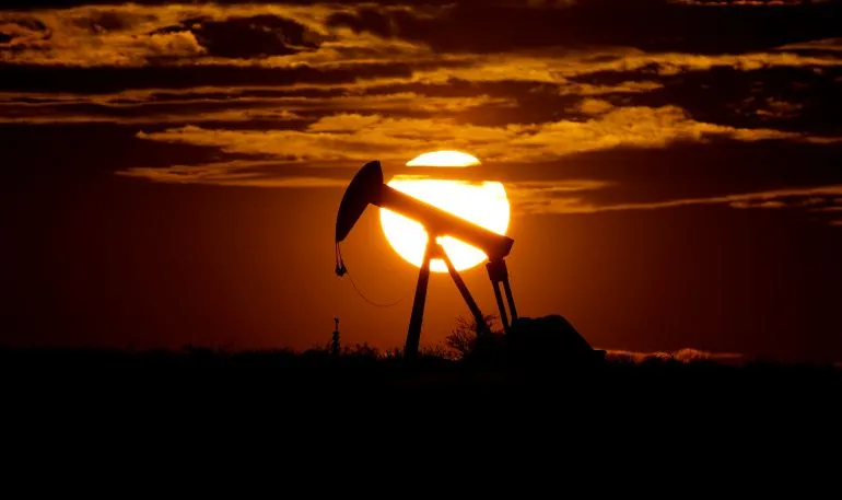 مضخة نفط silhouetted against a vibrant sunset, symbolizing the energy crisis and rising fuel prices impacting global economies, especially in developing nations.