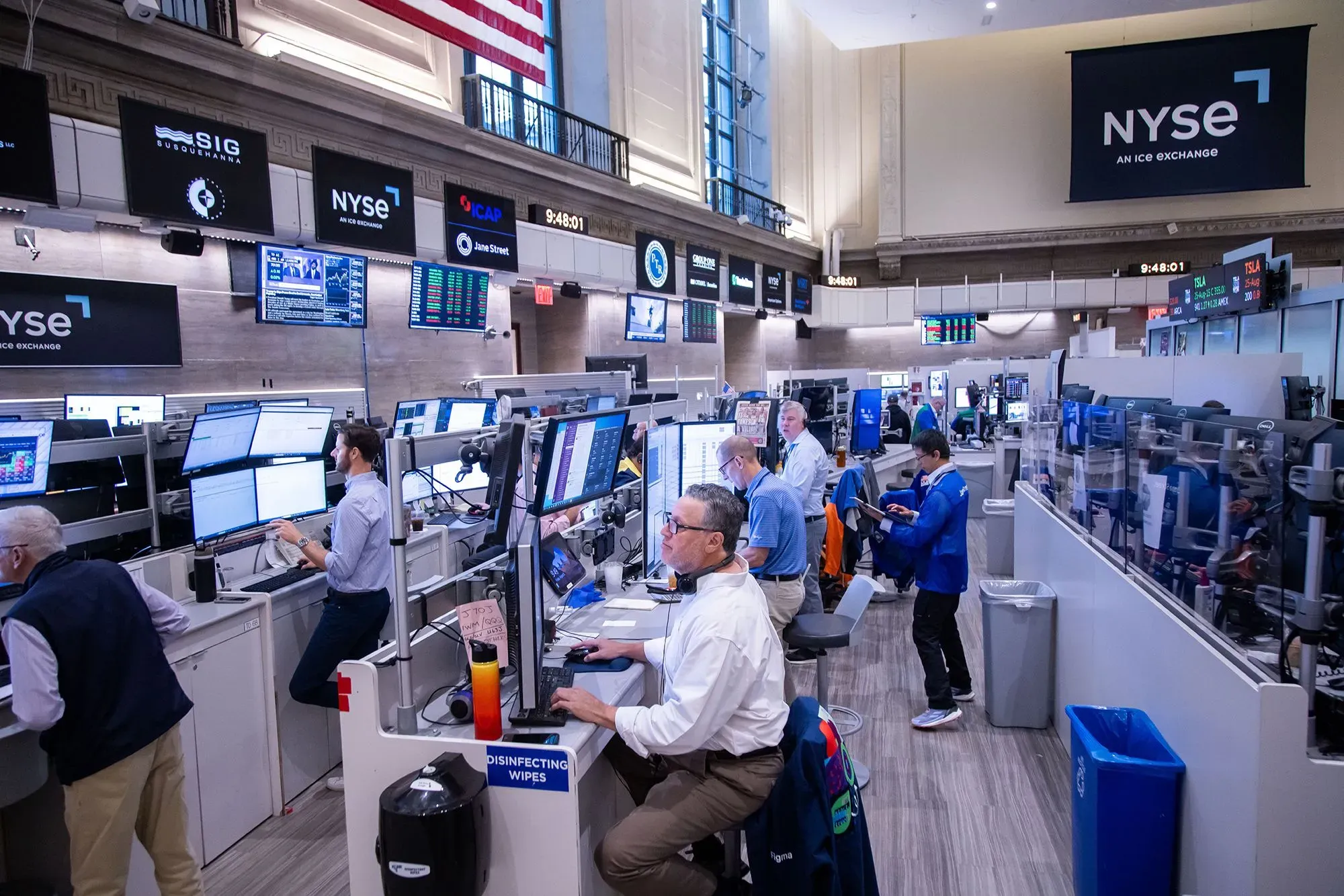 صورة لمتداولين في بورصة نيويورك، حيث تتواجد شاشات عرض أسعار الذهب والبيانات المالية وسط أجواء من النشاط والتوتر بسبب الرسوم الجمركية الجديدة.