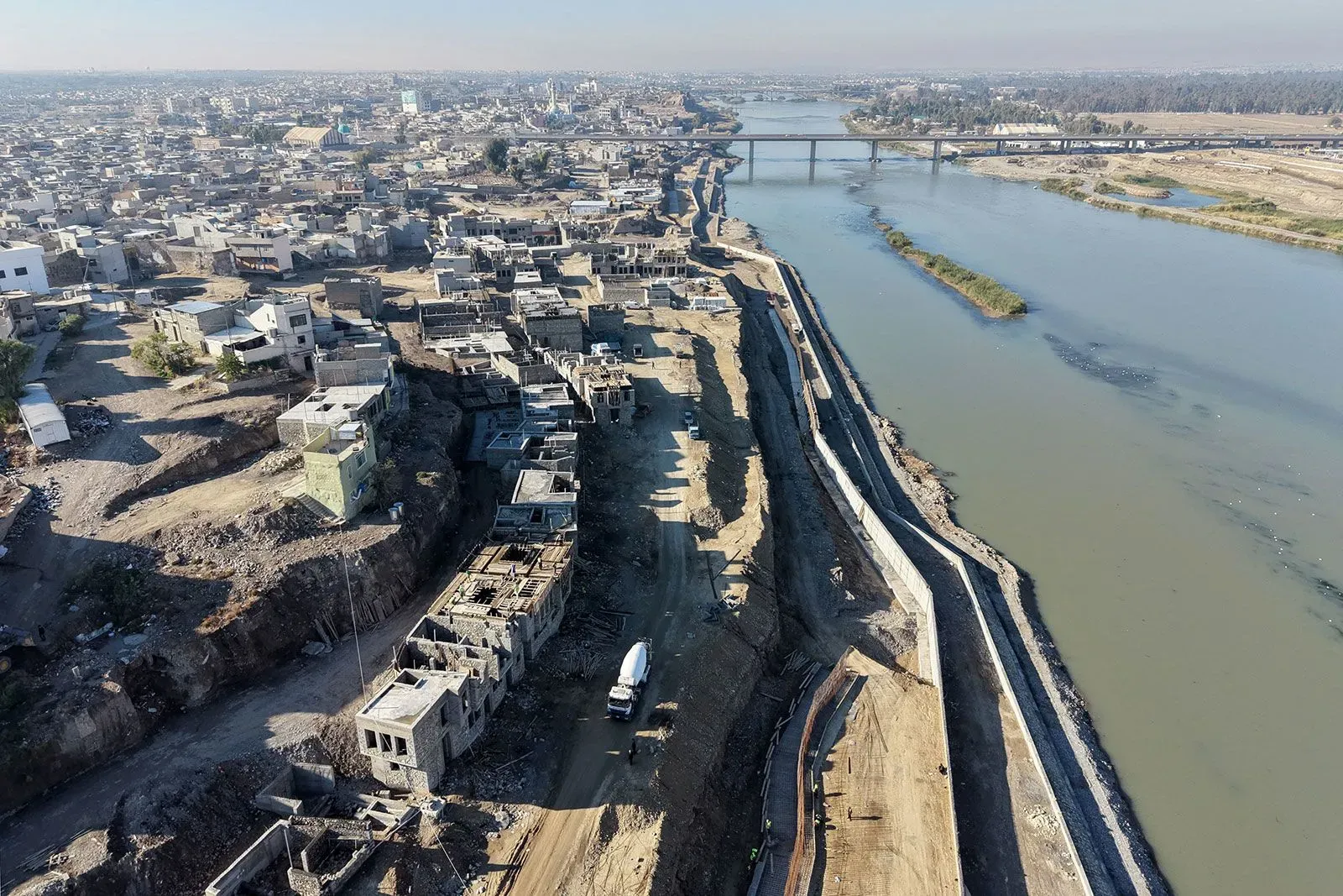 صورة تظهر مجرى نهر مع بنية تحتية قيد الإنشاء، تعكس أزمة المياه في العراق وتأثير الجفاف وسدود المنبع.