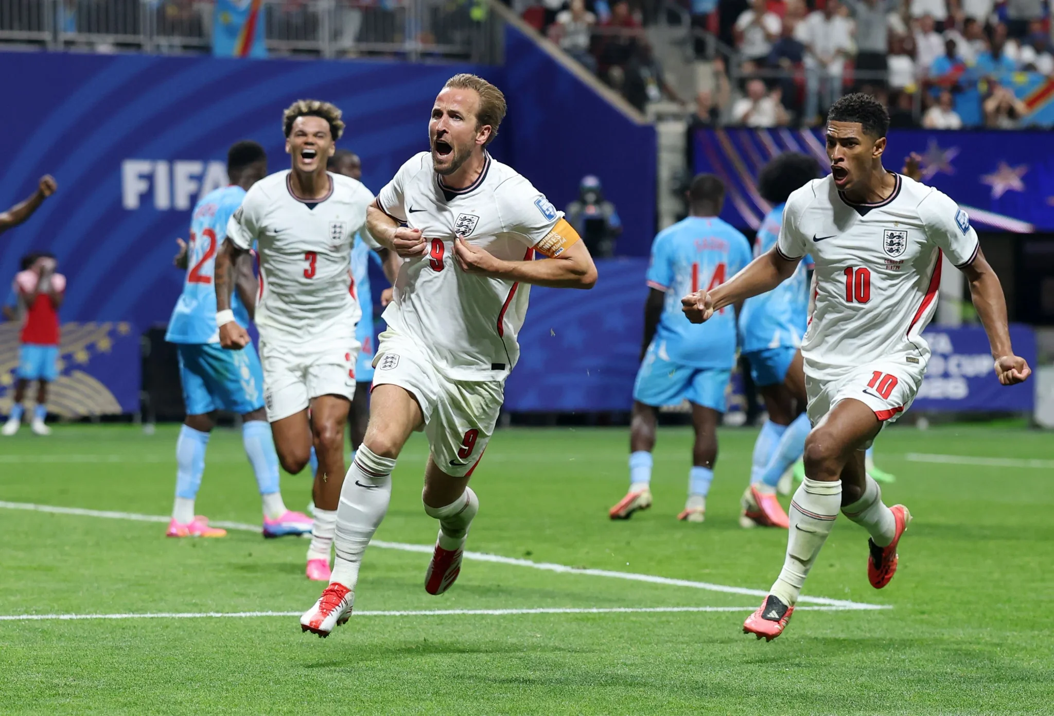 هاري كين يحتفل بهدف حاسم مع منتخب إنجلترا في مباراة كأس العالم ضد الكونغو، وسط فرحة اللاعبين والجمهور.