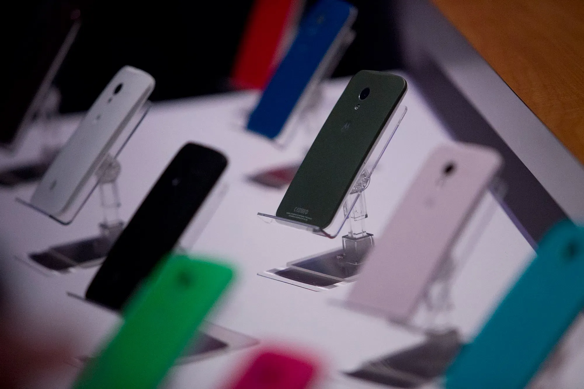 عرض لمجموعة من هواتف موتورولا الذكية بألوان متنوعة، تم عرضها على حاملات في معرض، مما يعكس جهود الشركة في تخصيص المنتجات.