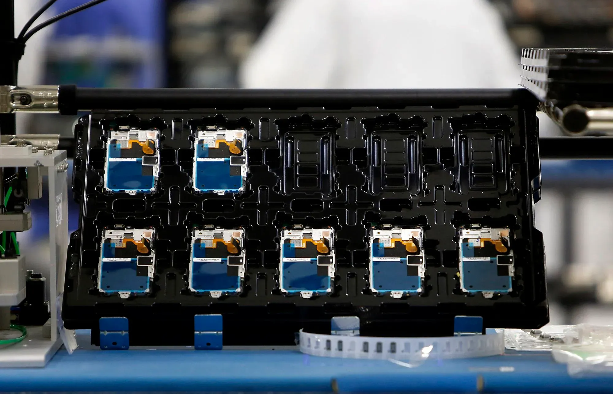 صورة لخط تجميع يحتوي على وحدات هاتف ذكي Moto X في مصنع موتورولا، مع التركيز على التفاصيل الفنية والتجميع المحلي.