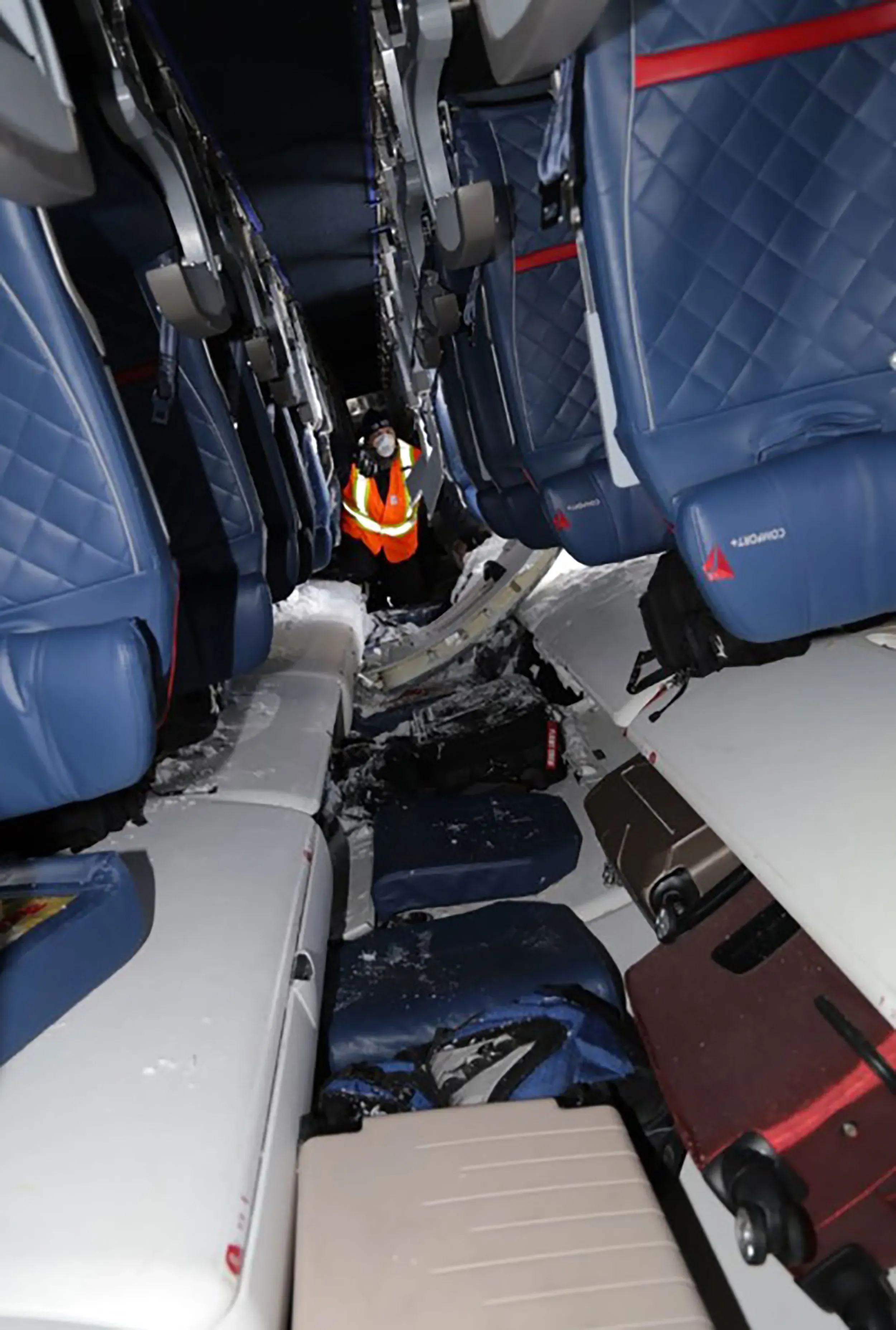 داخل الطائرة المقلوبة، يظهر أحد رجال الإنقاذ وهو يساعد الركاب في الخروج من مقاعدهم بعد حادث تحطم.