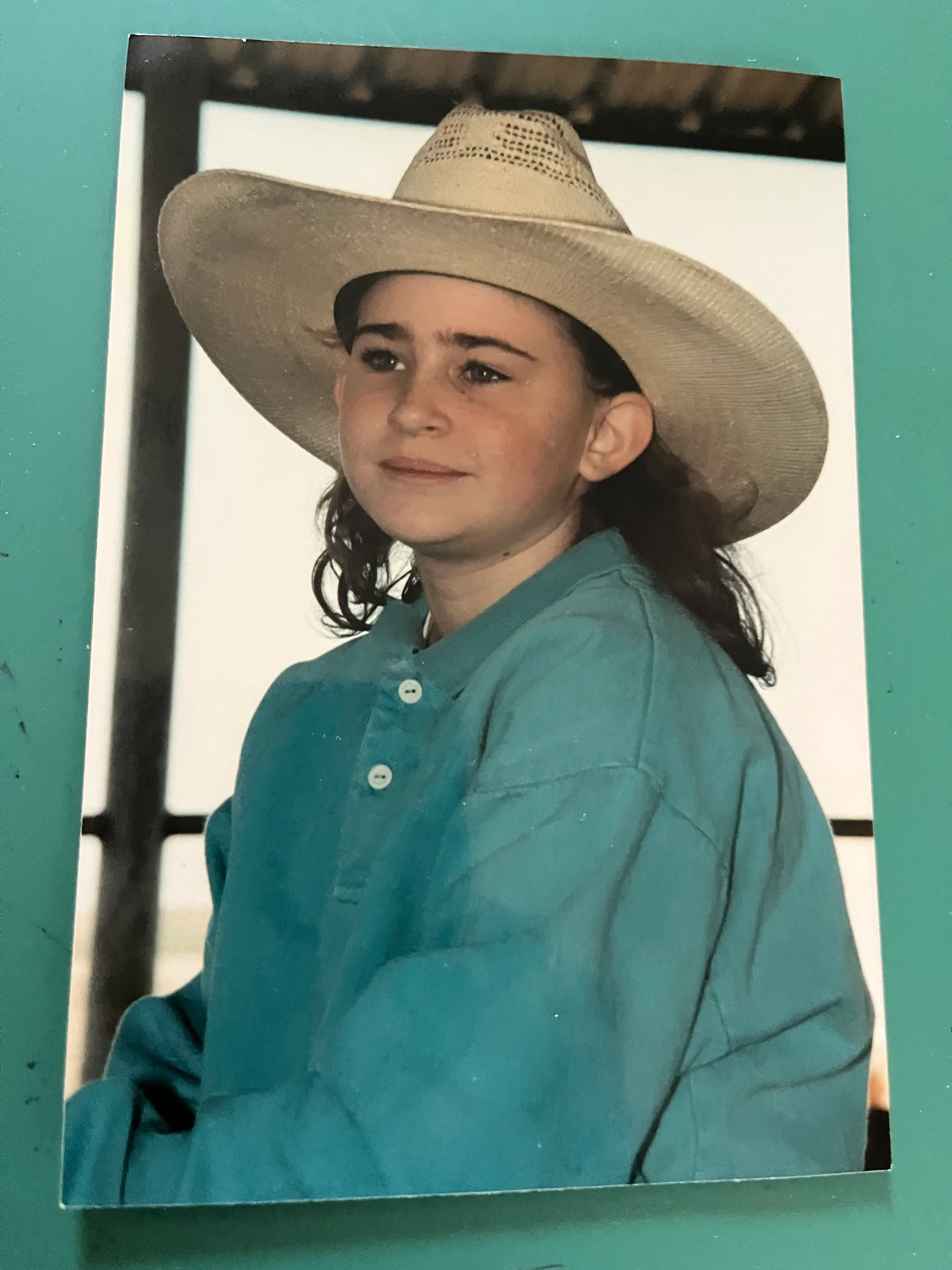 صورة لفتاة صغيرة ترتدي قبعة رعاة البقر وقميص أزرق، تعكس ذكريات مؤلمة مرتبطة بقضية قتل مراهقات في تكساس.