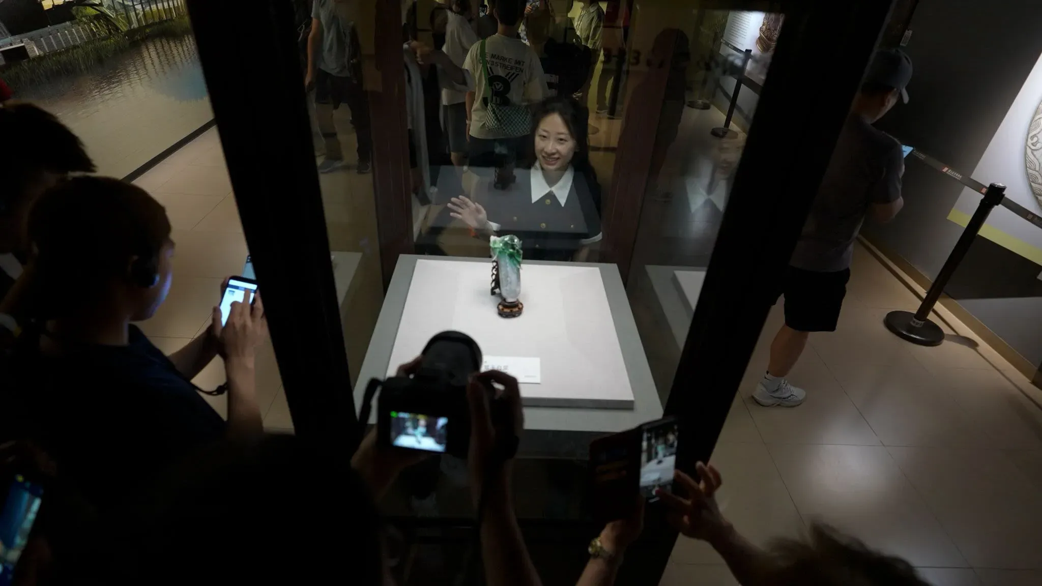 زوار متحف القصر الوطني في تايبيه يتجمعون حول منحوتة ملفوف الجاديت الشهيرة، مع تصويرها من زوايا متعددة.