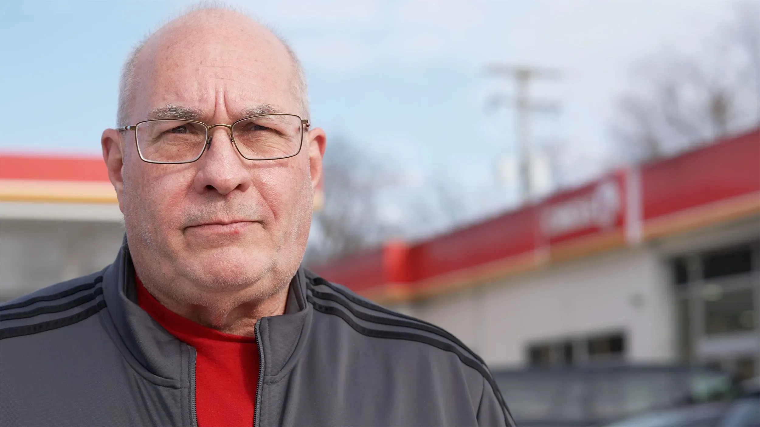 رجل مسن يقف أمام متجر Circle K، يعبر عن استيائه من عمليات الاحتيال على أجهزة الصراف الآلي للعملات الرقمية التي تستهدف الضحايا.