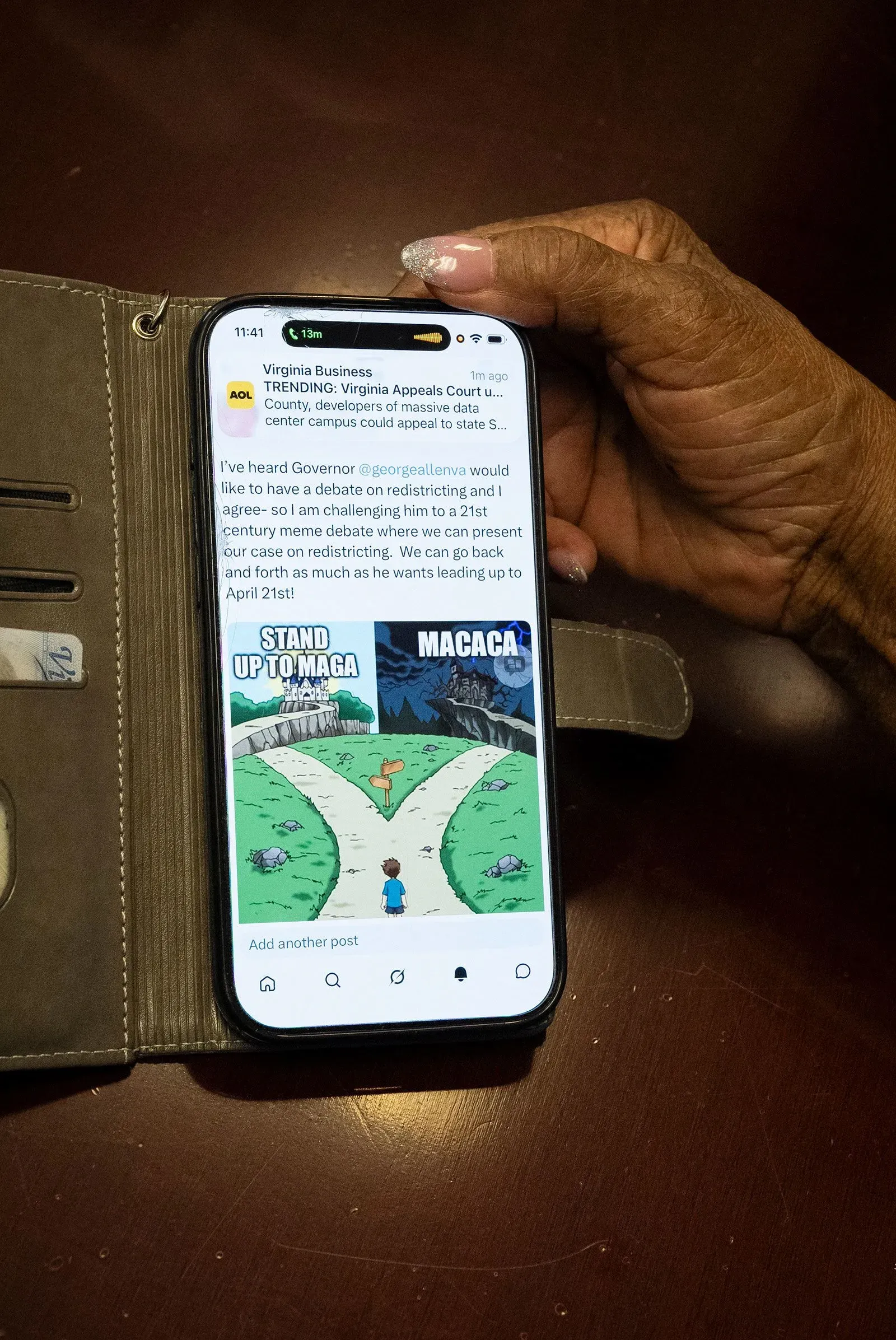 صورة لهاتف ذكي يحمل منشورًا عن إعادة تقسيم الدوائر الانتخابية، مع رسم كاريكاتوري يظهر خيارات مختلفة. يعكس النقاش السياسي حول الانتخابات في فرجينيا.