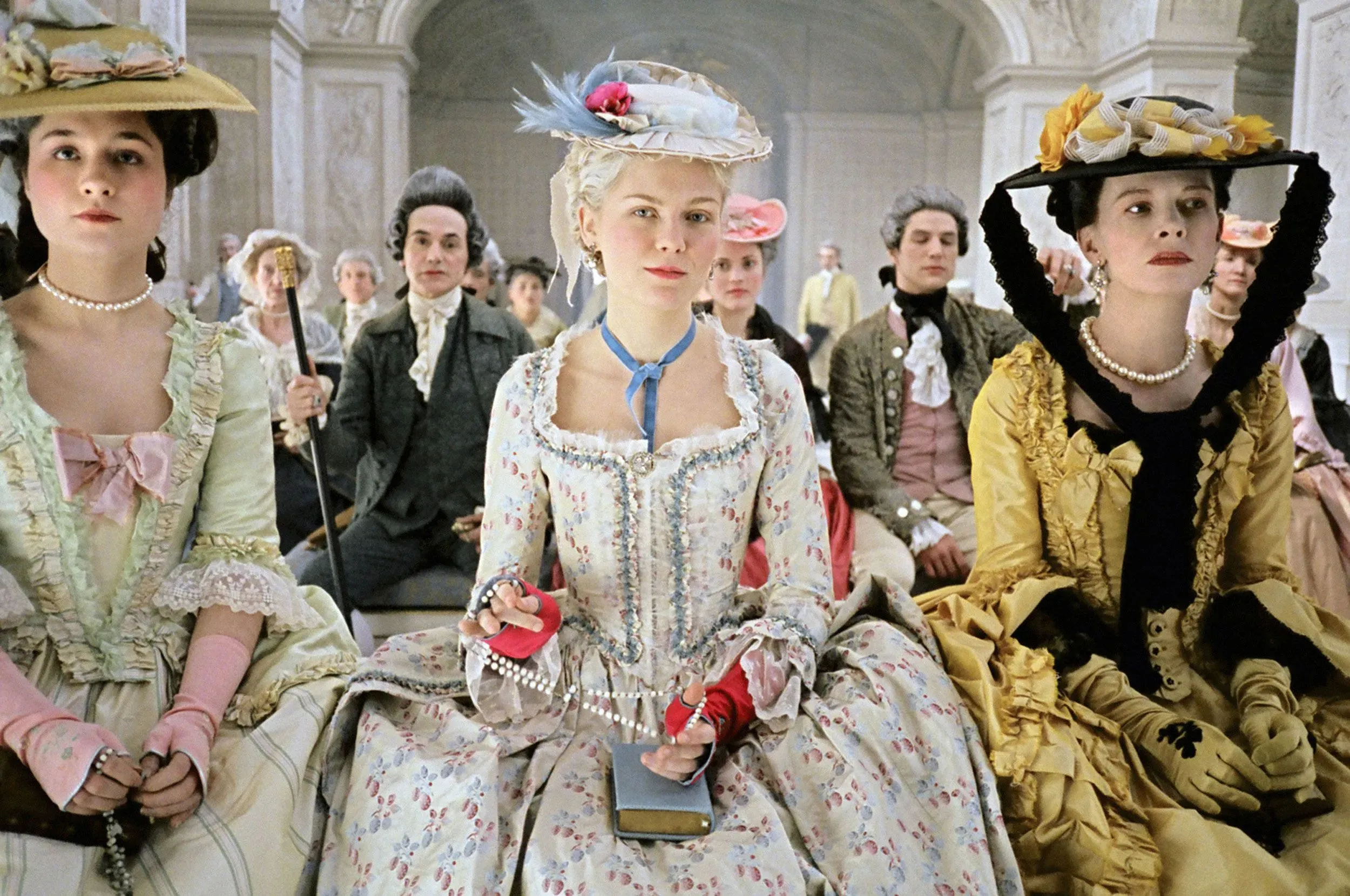 نساء يرتدين فساتين تاريخية من القرن الثامن عشر في عرض أزياء، يتجسد فيه إرث ماري أنطوانيت كأيقونة للموضة.