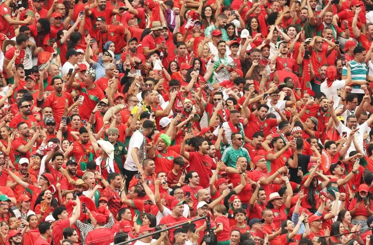 جماهير مغربية متحمسة ترتدي الأحمر والأخضر، تعبر عن دعمها القوي لمنتخب المغرب في بطولة كأس العالم FIFA 2026.