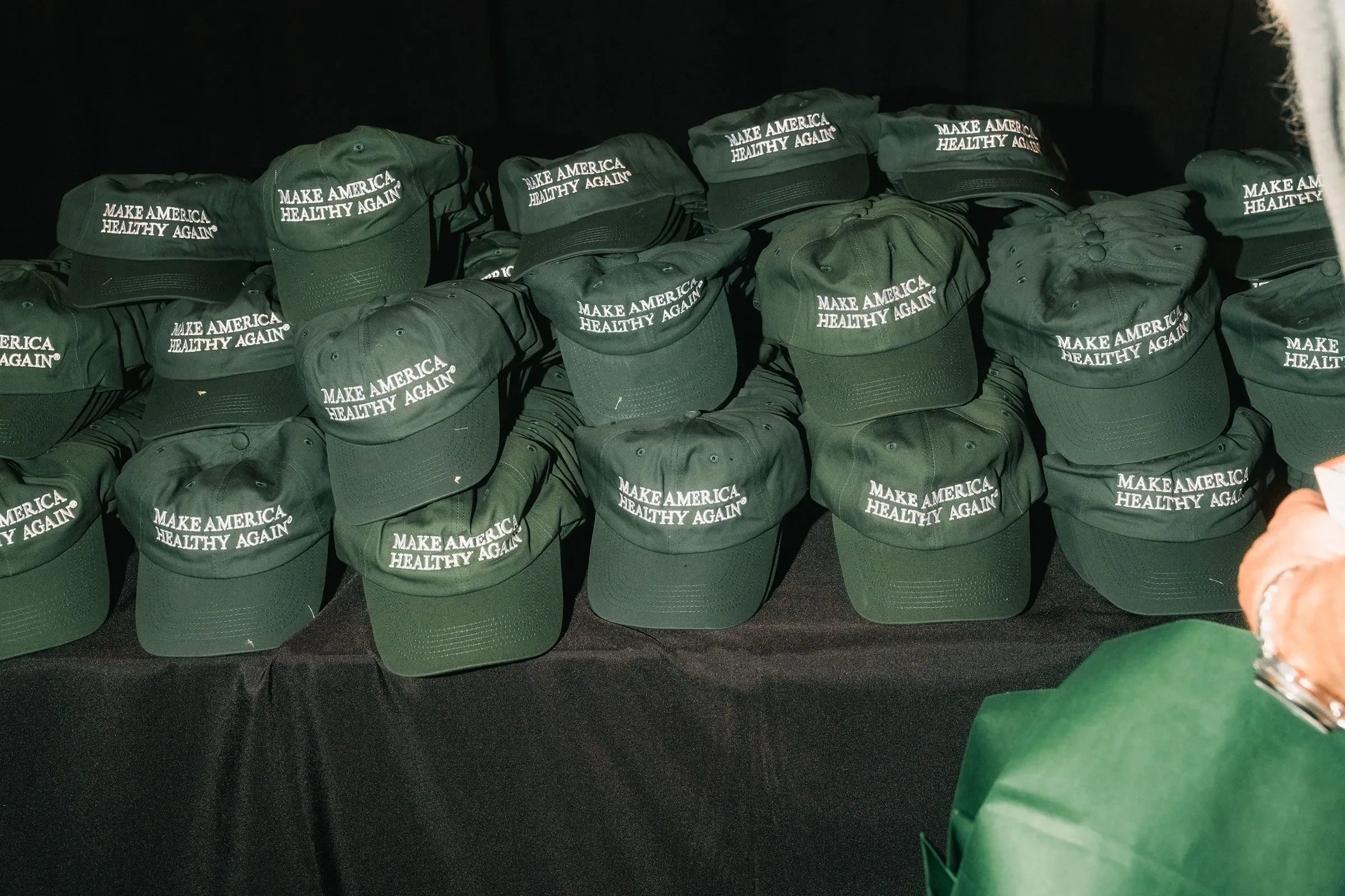 قبعات خضراء مكتوب عليها "اجعلوا أمريكا صحية مرة أخرى" مكدسة في مجموعة، تعكس الجهود السياسية لتعزيز الصحة العامة.