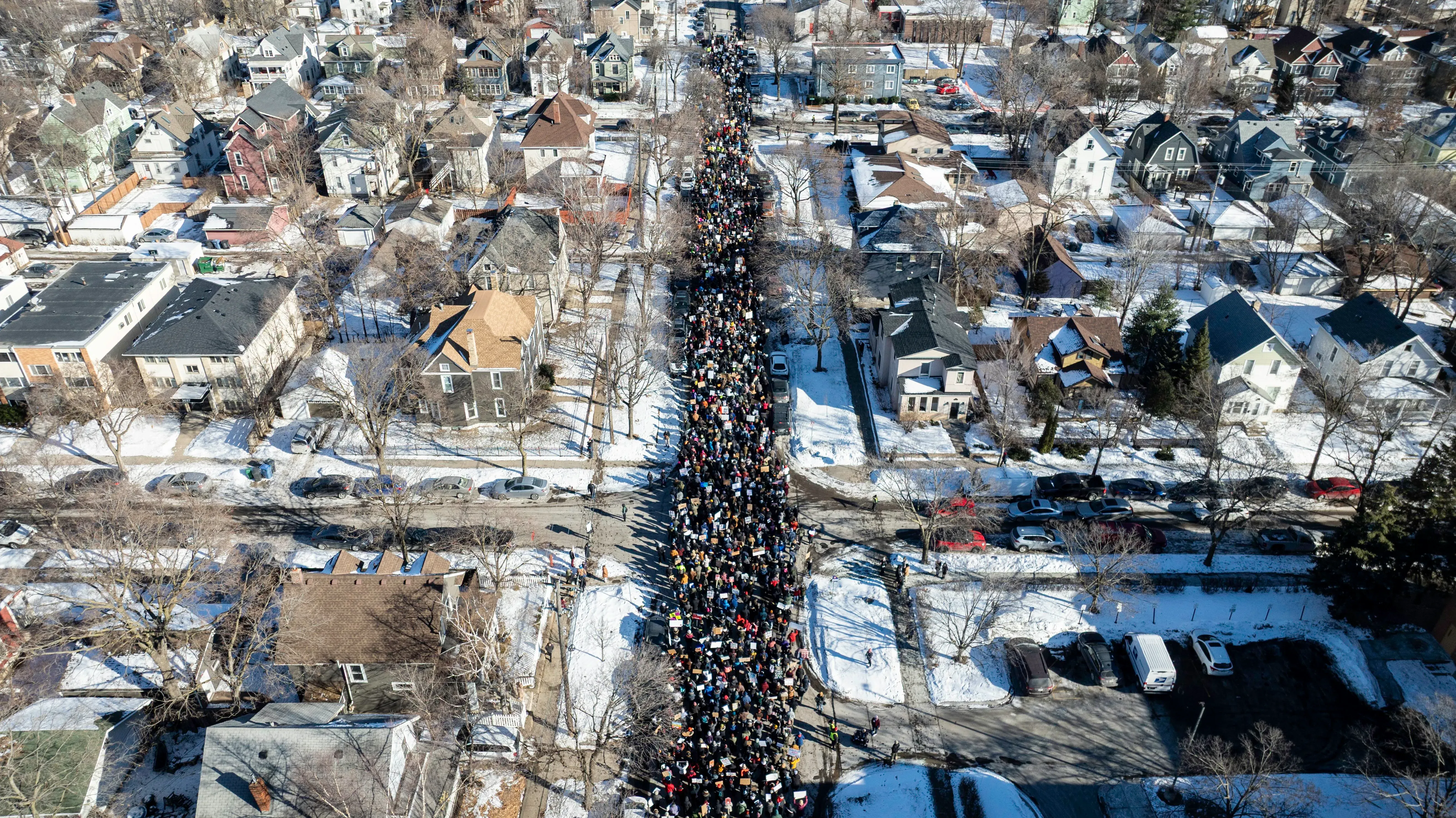 مظاهرة حاشدة في شوارع مينيسوتا، حيث يتجمع المتظاهرون في أعداد كبيرة وسط منازل ثلجية، تعبيرًا عن الغضب من السياسات الفيدرالية.