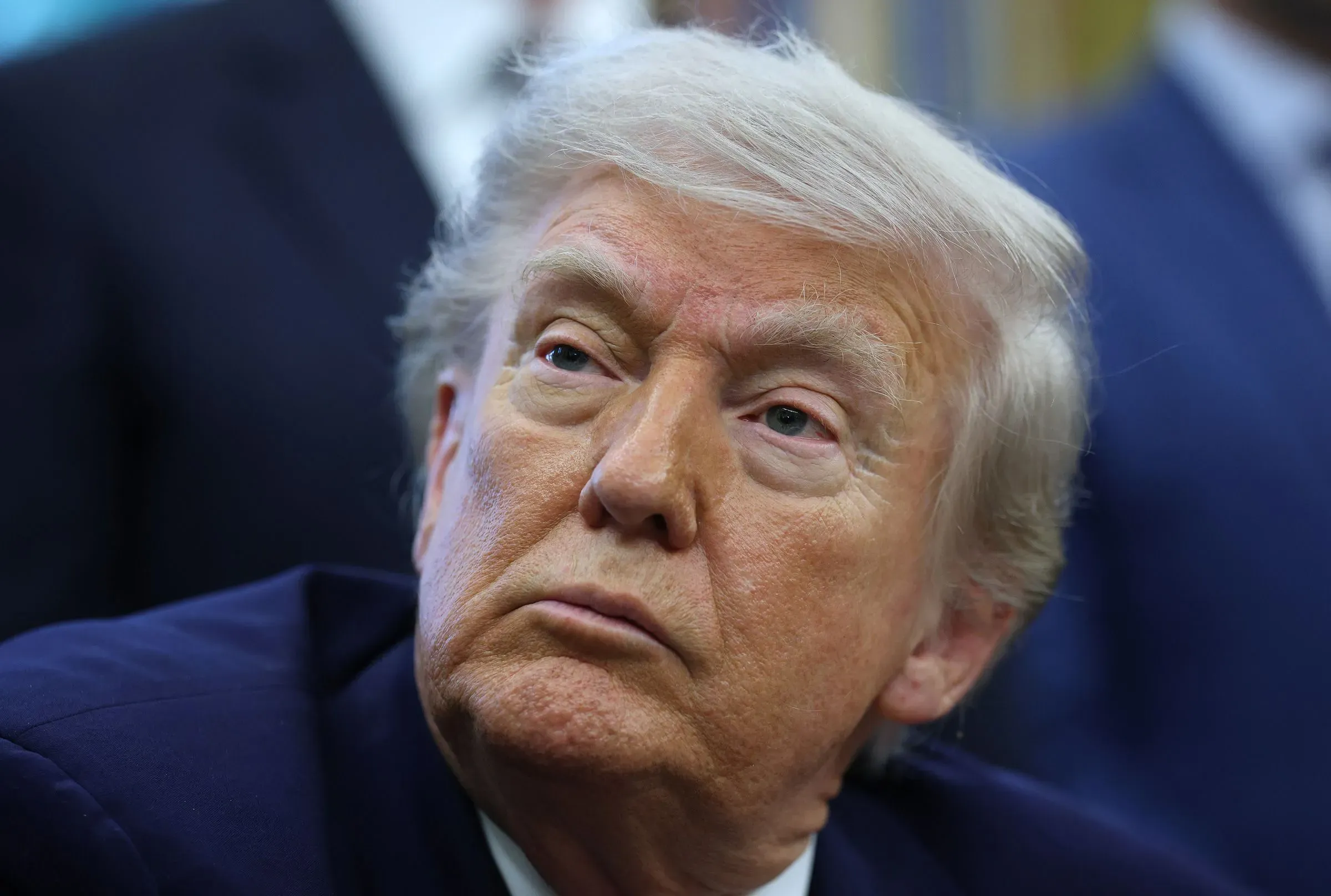 وجه الرئيس السابق دونالد ترامب نظرة تأملية خلال حدث رسمي، يعكس التوترات المتعلقة بالأمن النووي والميزانية الفيدرالية.