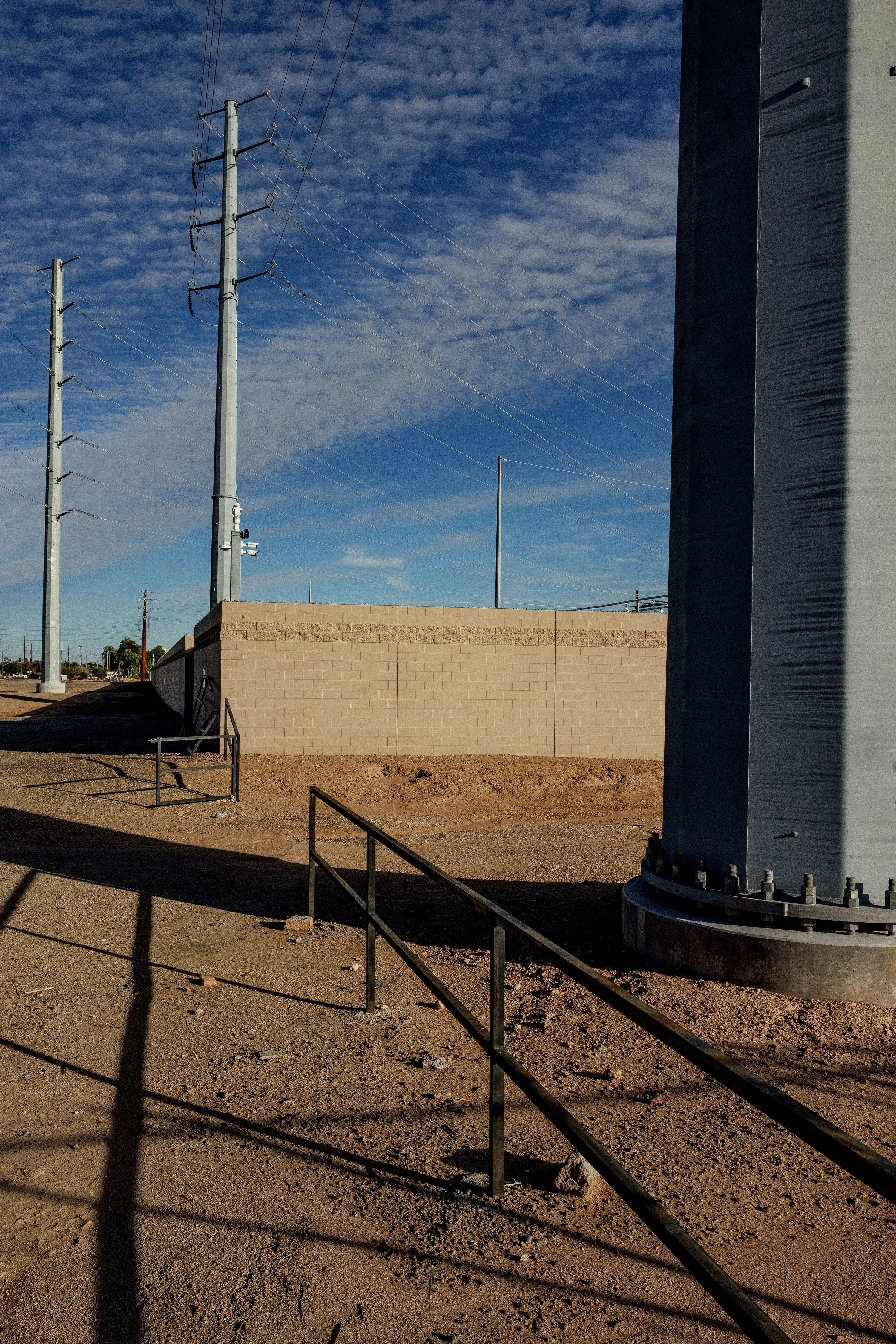 صورة تظهر بنية تحتية لمركز بيانات في تشاندلر، أريزونا، مع أعمدة كهرباء وخطوط كهرباء، تعكس التحديات البيئية والاقتصادية للمراكز التكنولوجية.