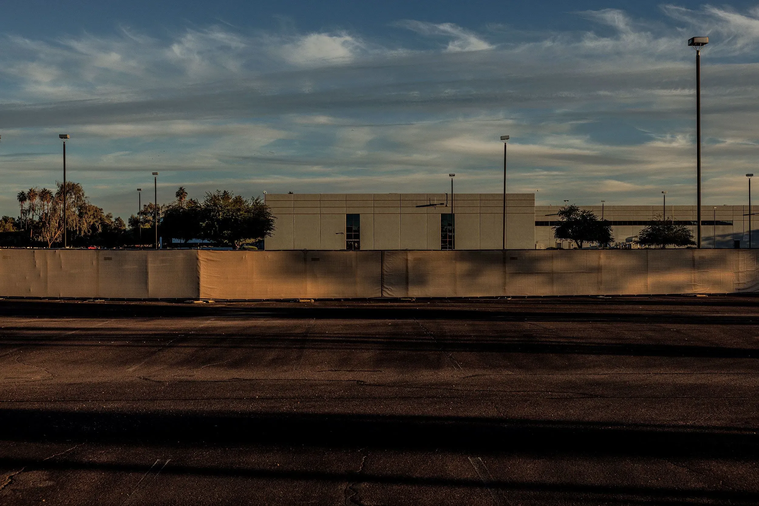 مركز بيانات قيد الإنشاء في تشاندلر بأريزونا، محاط بسياج، في منطقة تجارية تشهد جدلًا حول تأثير مراكز البيانات على المجتمع.