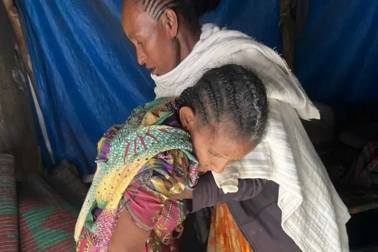 امرأتان في قرية هيتساتس بإثيوبيا، حيث تعاني المجتمعات من آثار المجاعة ونقص المساعدات الإنسانية. تعكس ملامحهما معاناة السكان.