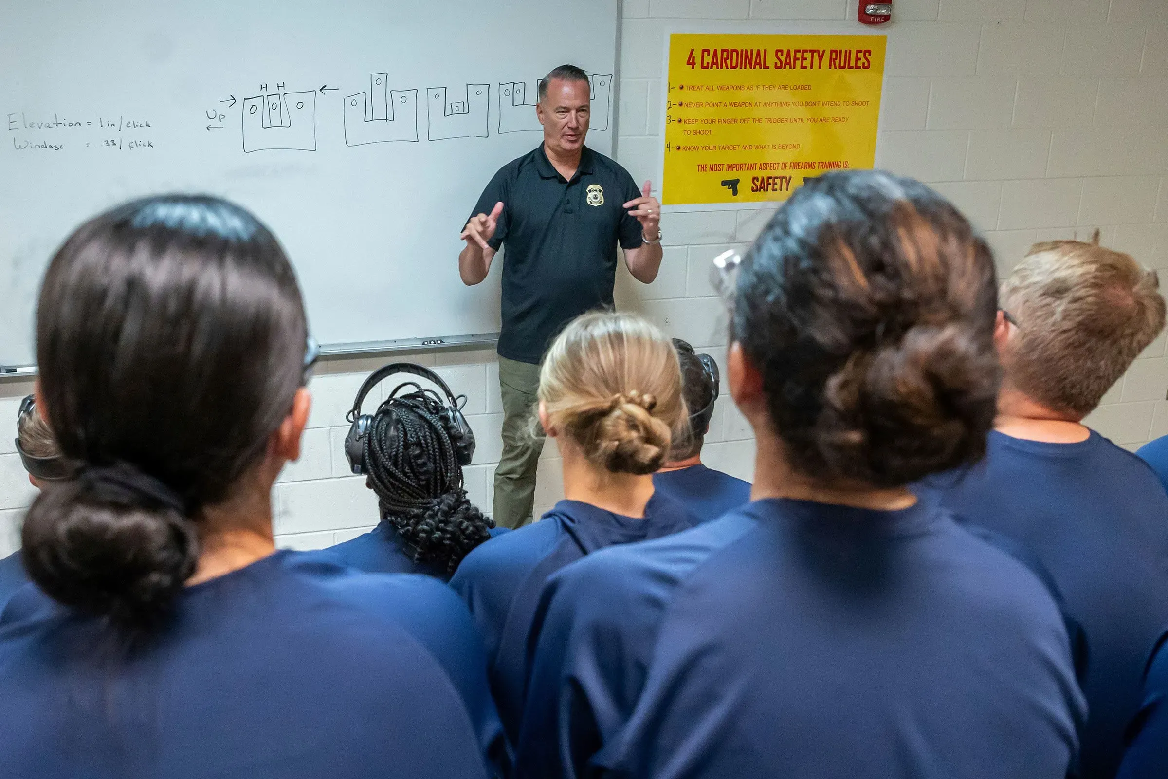 مدرب يشرح قواعد السلامة لضباط إنفاذ قوانين الهجرة والجمارك خلال جلسة تدريبية، مع التركيز على أهمية التدريب الكافي لمهامهم.