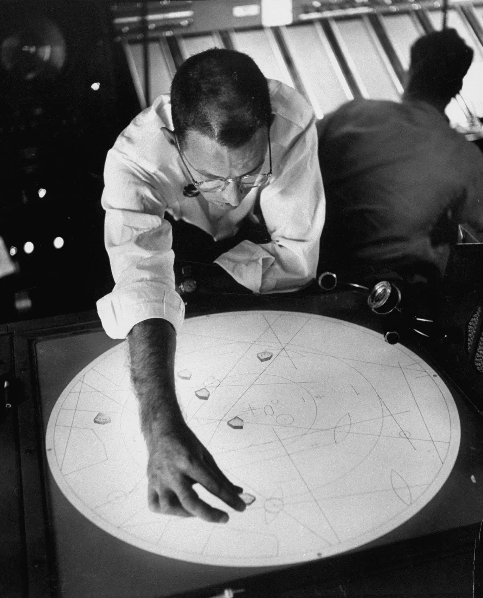 رجل يعمل على شاشة رادار قديمة، يحدد الأهداف الجوية غير المعروفة، في سياق أحداث مثيرة خلال الحرب الباردة.