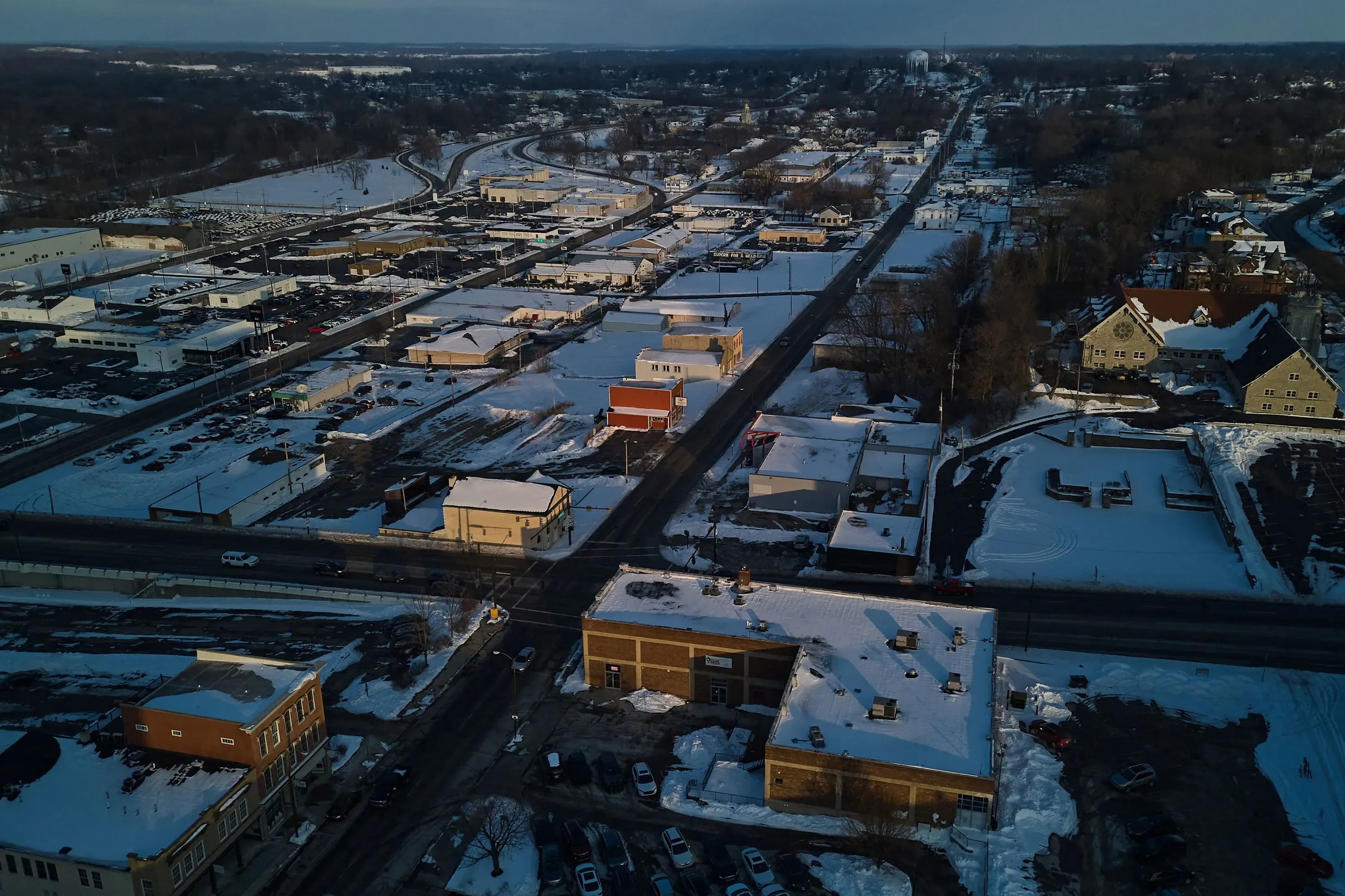 منظر جوي لمدينة سبرينغفيلد المغطاة بالثلوج، يظهر المباني والشوارع، مع التركيز على التحديات التي تواجه المهاجرين الهايتيين.