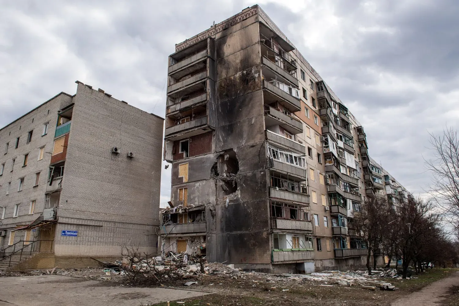 مبنى سكني مدمر في شرق أوكرانيا يظهر آثار الهجمات العسكرية، مع بقايا الحطام حوله، مما يعكس الوضع الصعب في المنطقة.